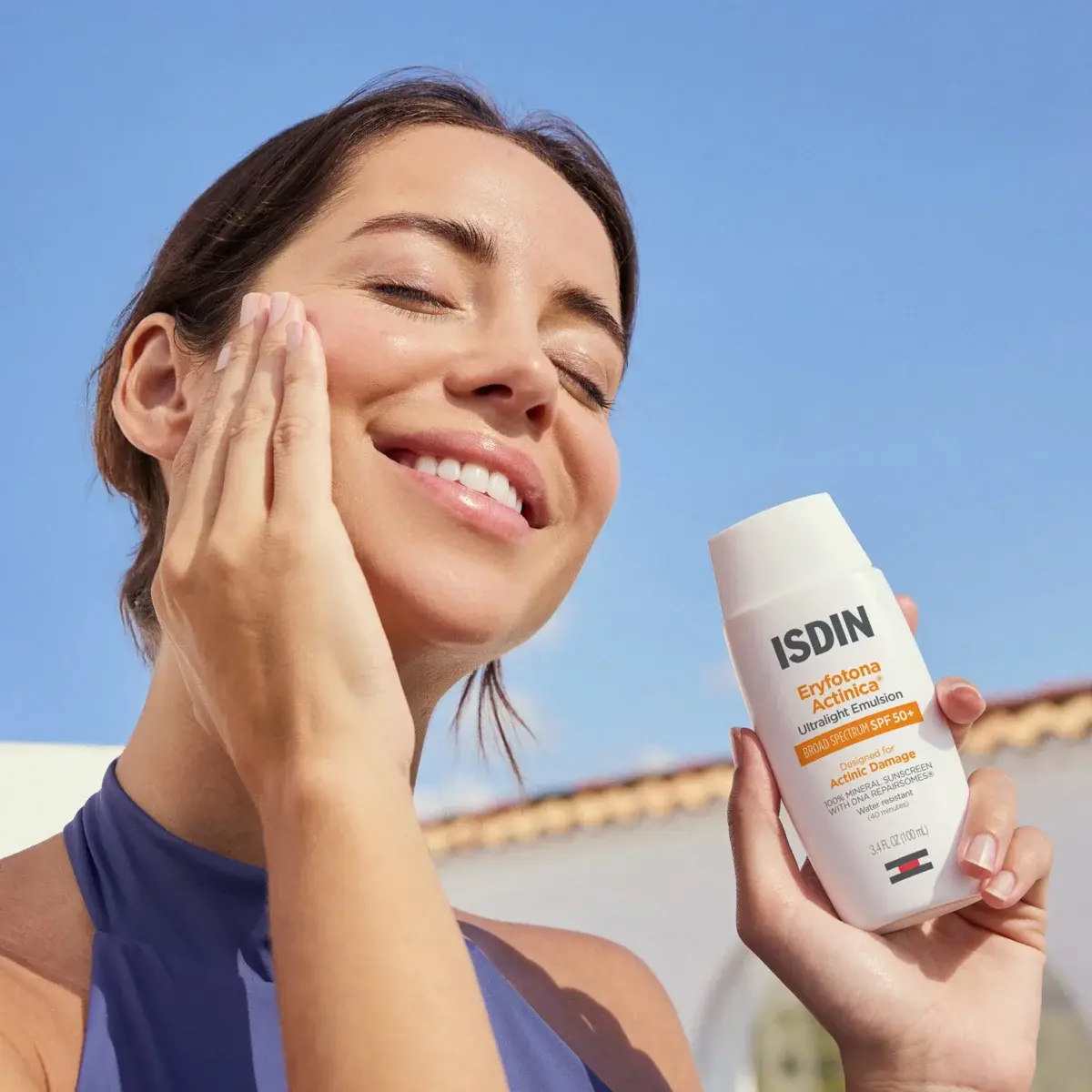 Woman applies ISDIN product to her face