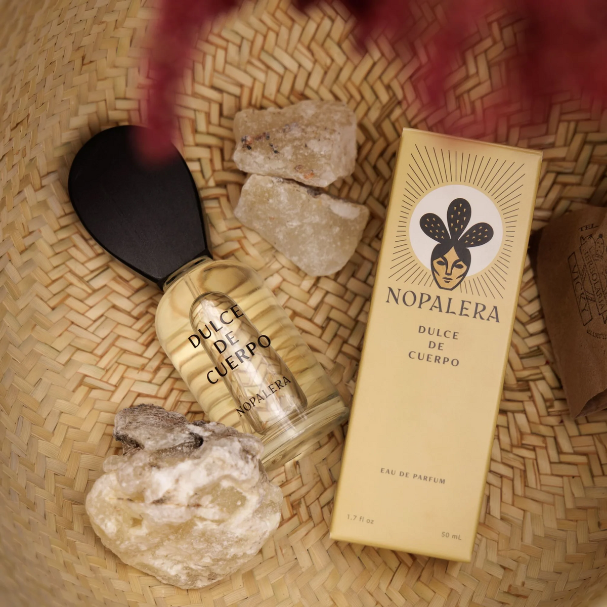 Nopalera perfume bottle and packaging on a woven surface with rocks