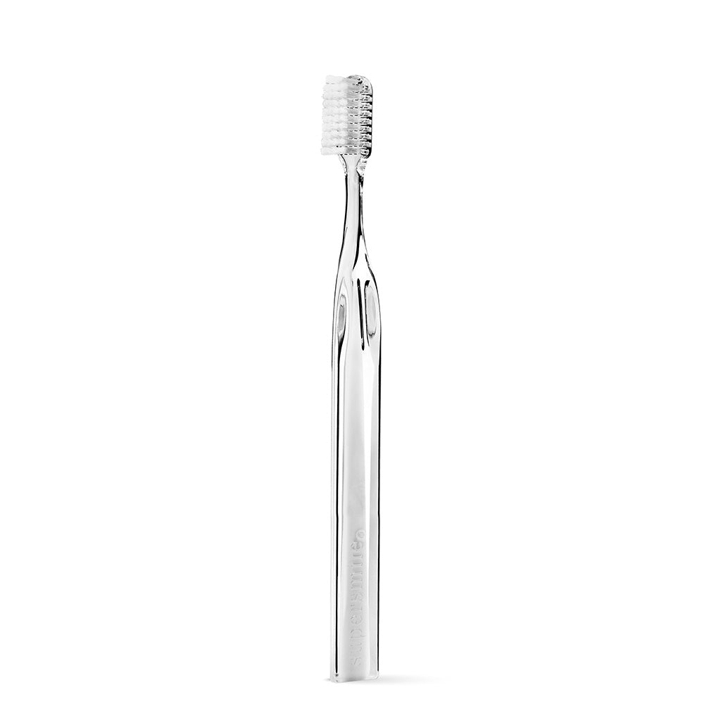 Clear Supersmile  plastic toothbrush on a white background