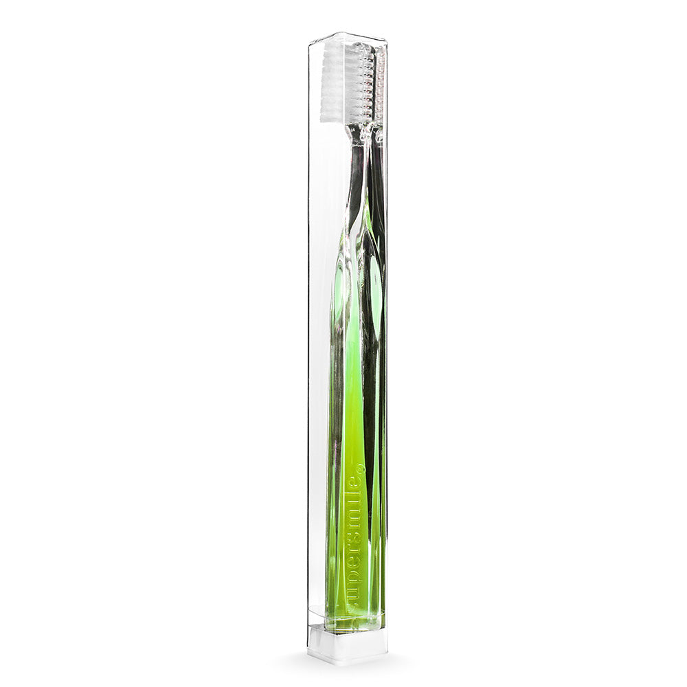Supersmile Green toothbrush in a clear packaging box on a white background