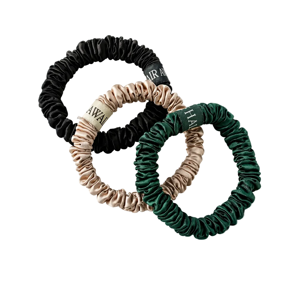 Three hair scrunchies in black, beige, and green on a white background
