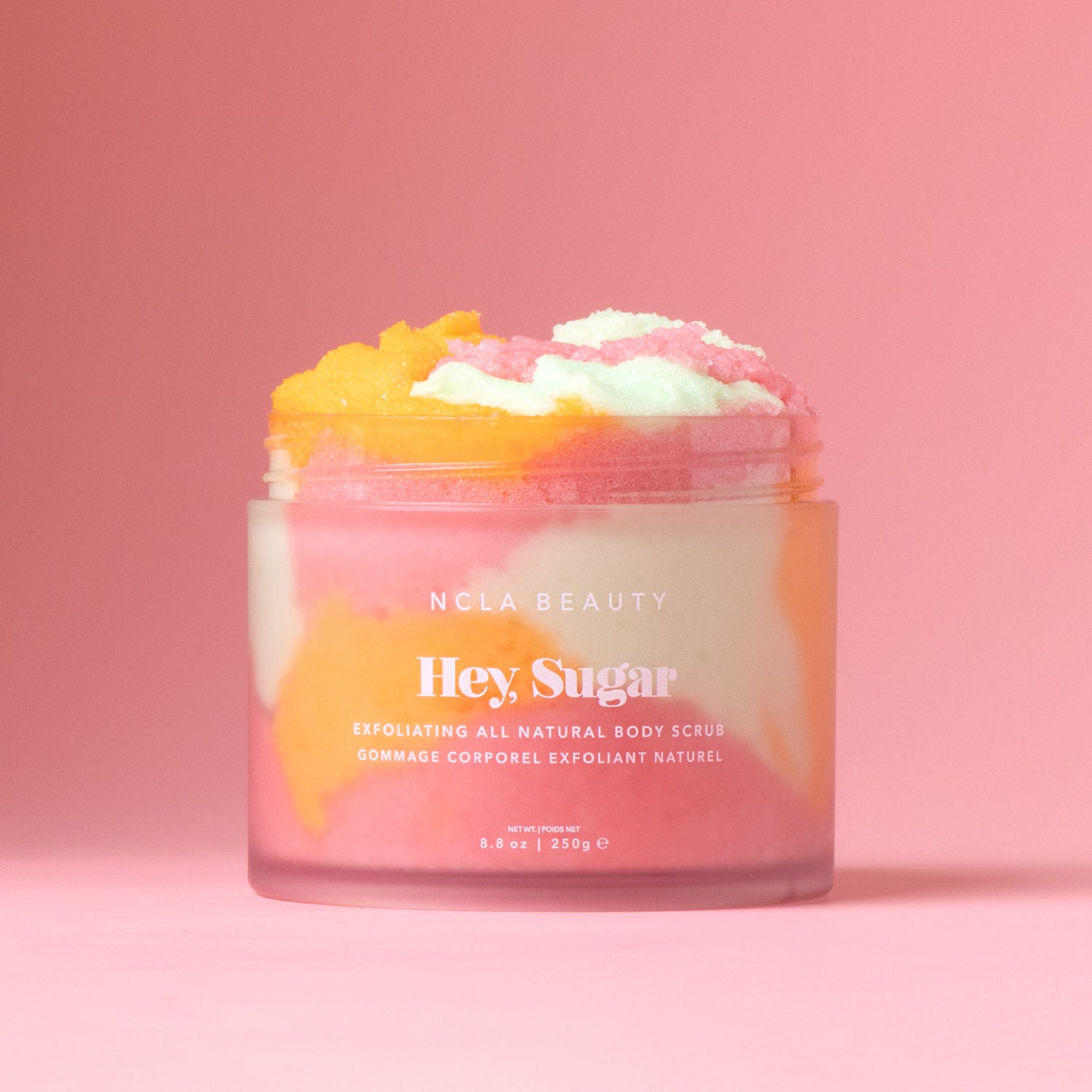 Jar of NCLA Beauty 'Hey Sugar' body scrub on a pink background