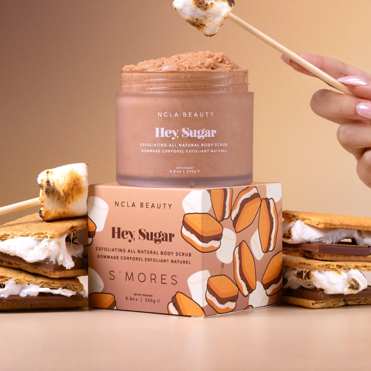 NCLA Beauty 'Hey Sugar' S'mores themed body scrub with packaging and marshmallows on a beige background