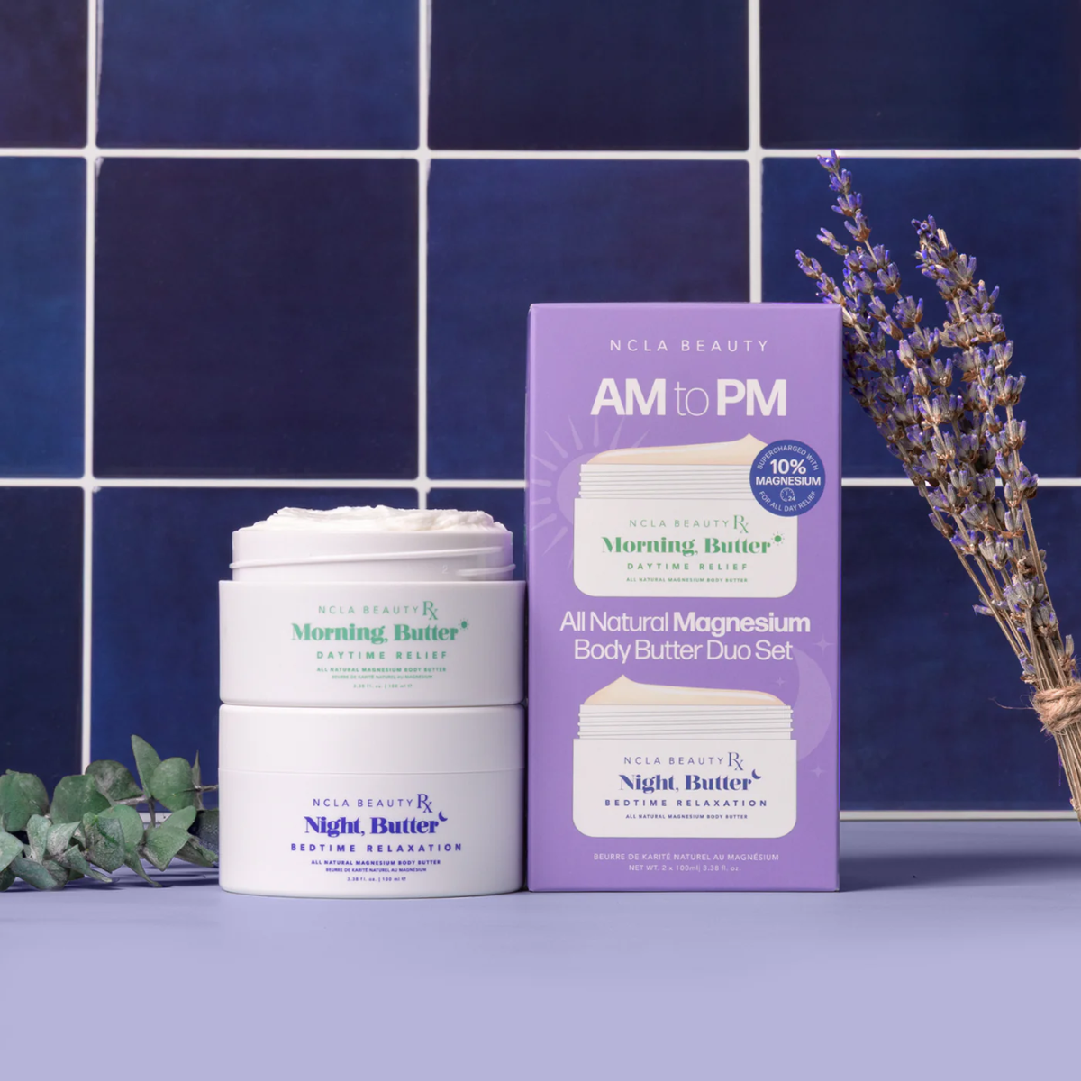 NCLA Beauty AM to PM All Natural Magnesium Body Butter Duo Set against a blue tiled wall.