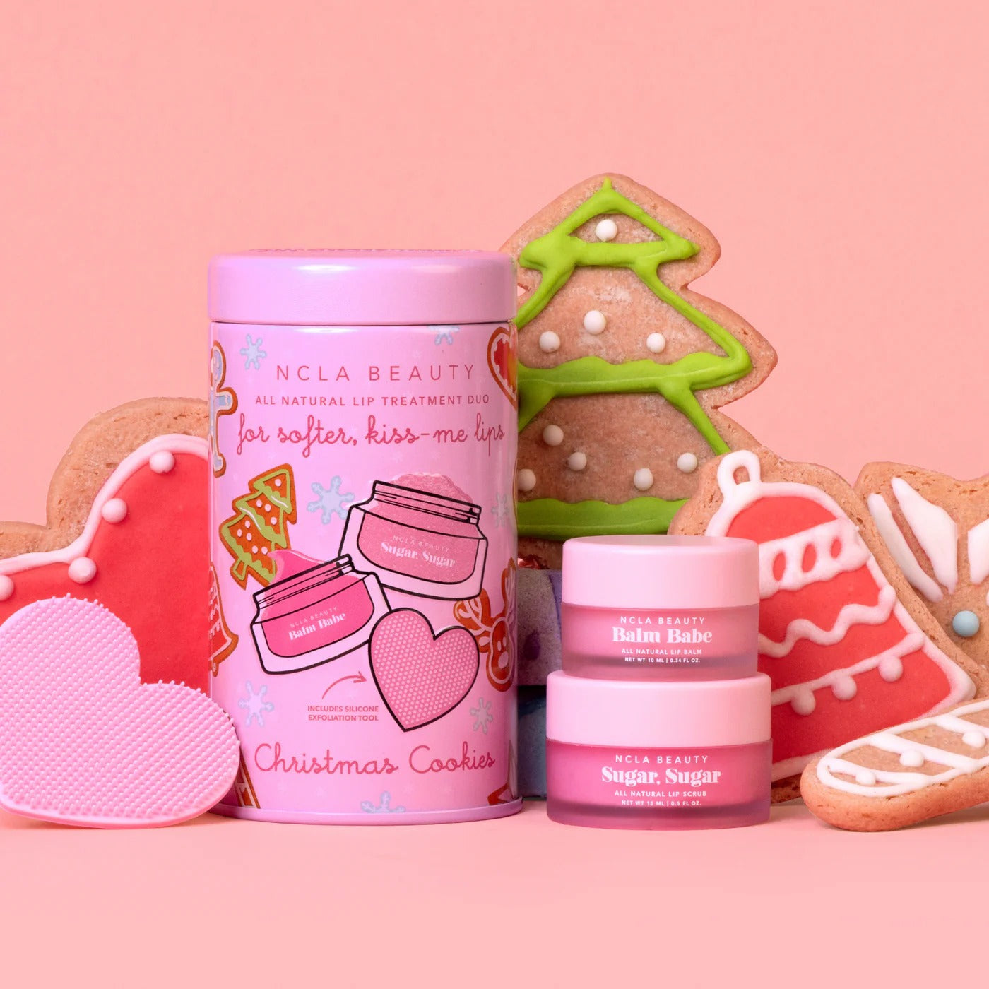 NCLA Beauty lip treatment product with Christmas cookies on a pink background