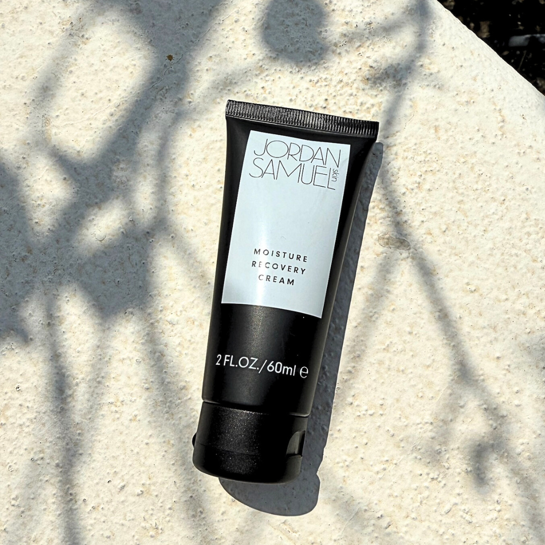 Black tube of Jordan Samuele cream on a textured surface with leaf shadows