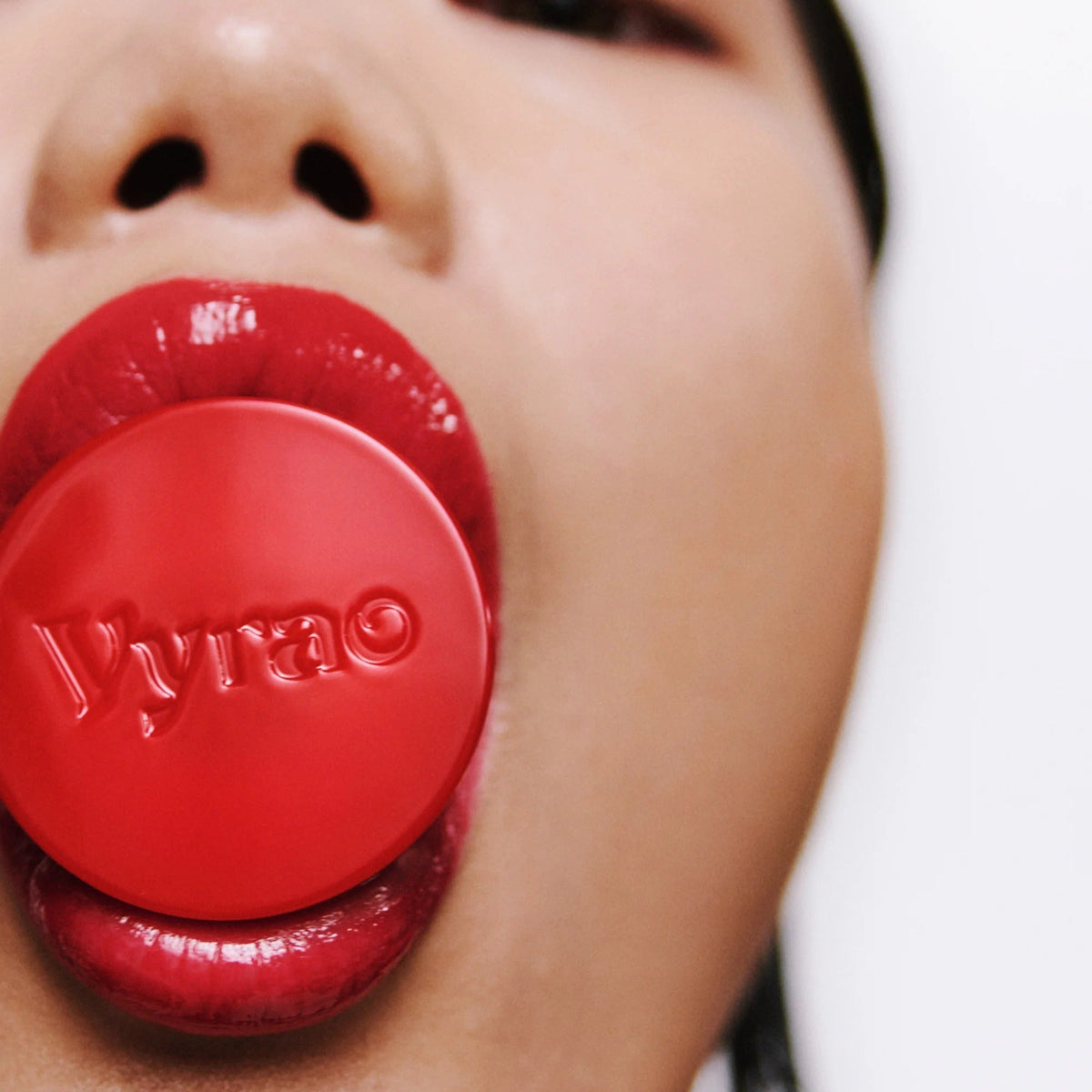 Close-up of a person wearing a red lipstick with 'Vyrao' branding.