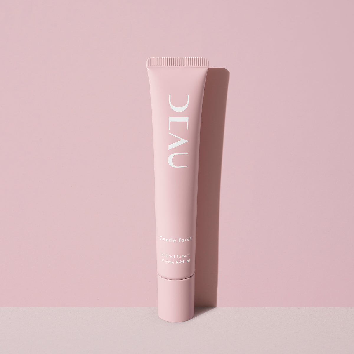 Pink skincare tube with brand name Deau on a matching pink background