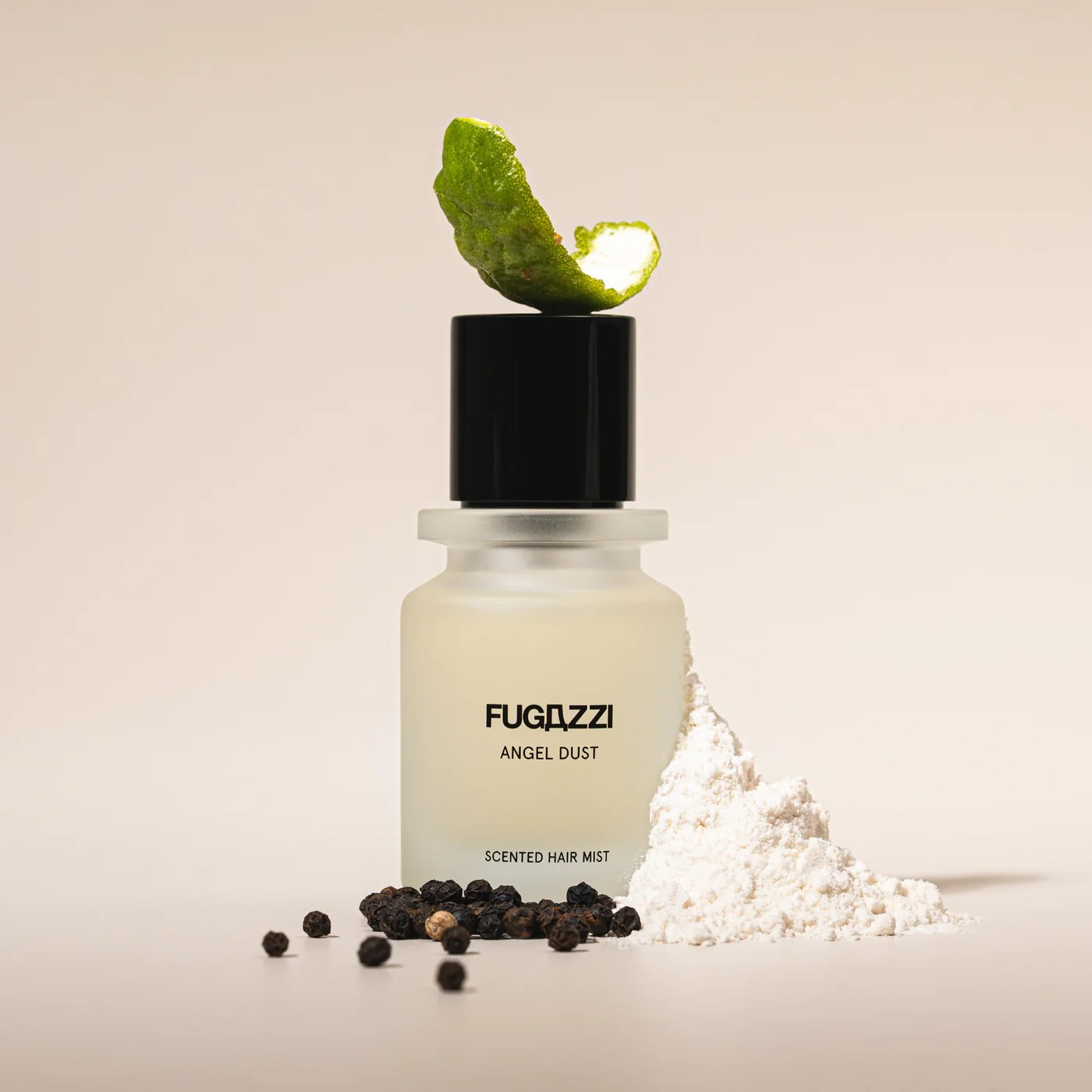 fugazzi scented hair mist bottle with lime wedge, powder and peppercorns around it.