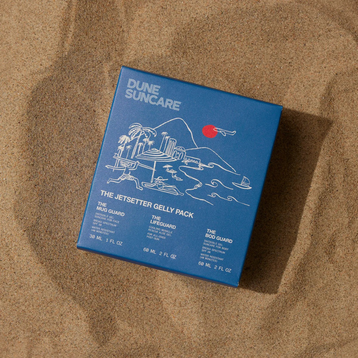 Blue packaging of Dune Suncare on a sandy background