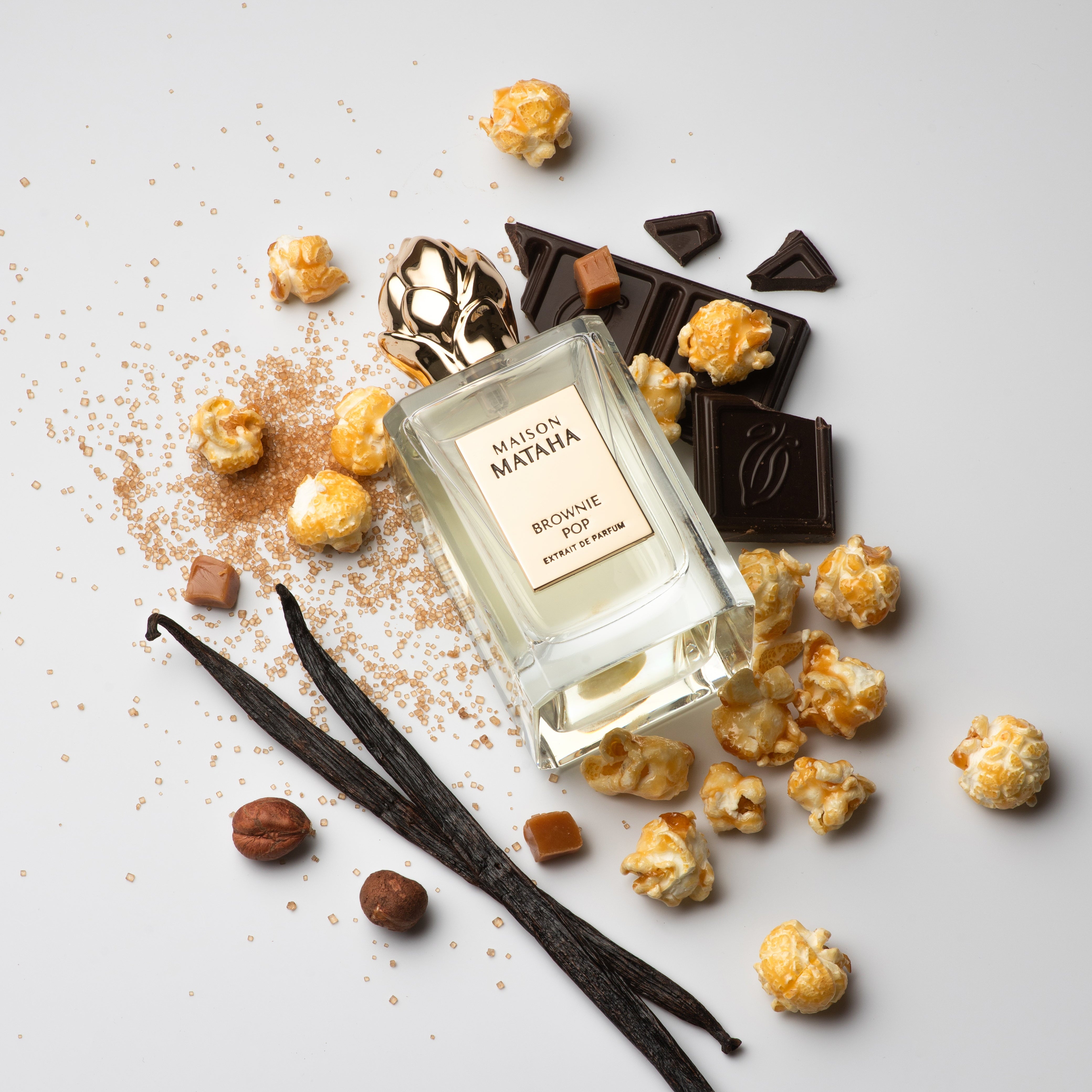 Maison Mataha perfume surrounded by chocolate, hazelnuts, and caramel corn