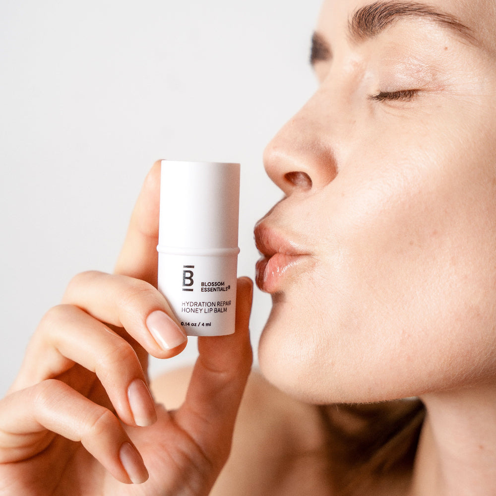 Woman applying skincare product to her face with a neutral background
