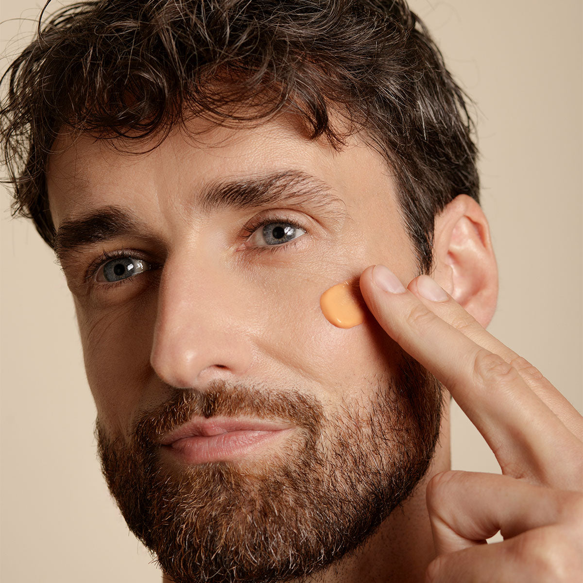 Man applying Embryolisse Radiant Complexion Cream in Apricot Glow.