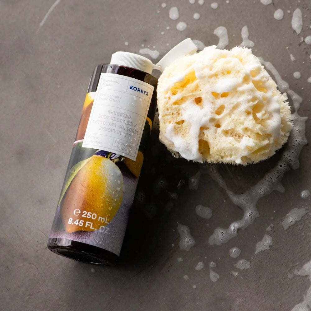 Korres bottle with a sponge on a gray surface