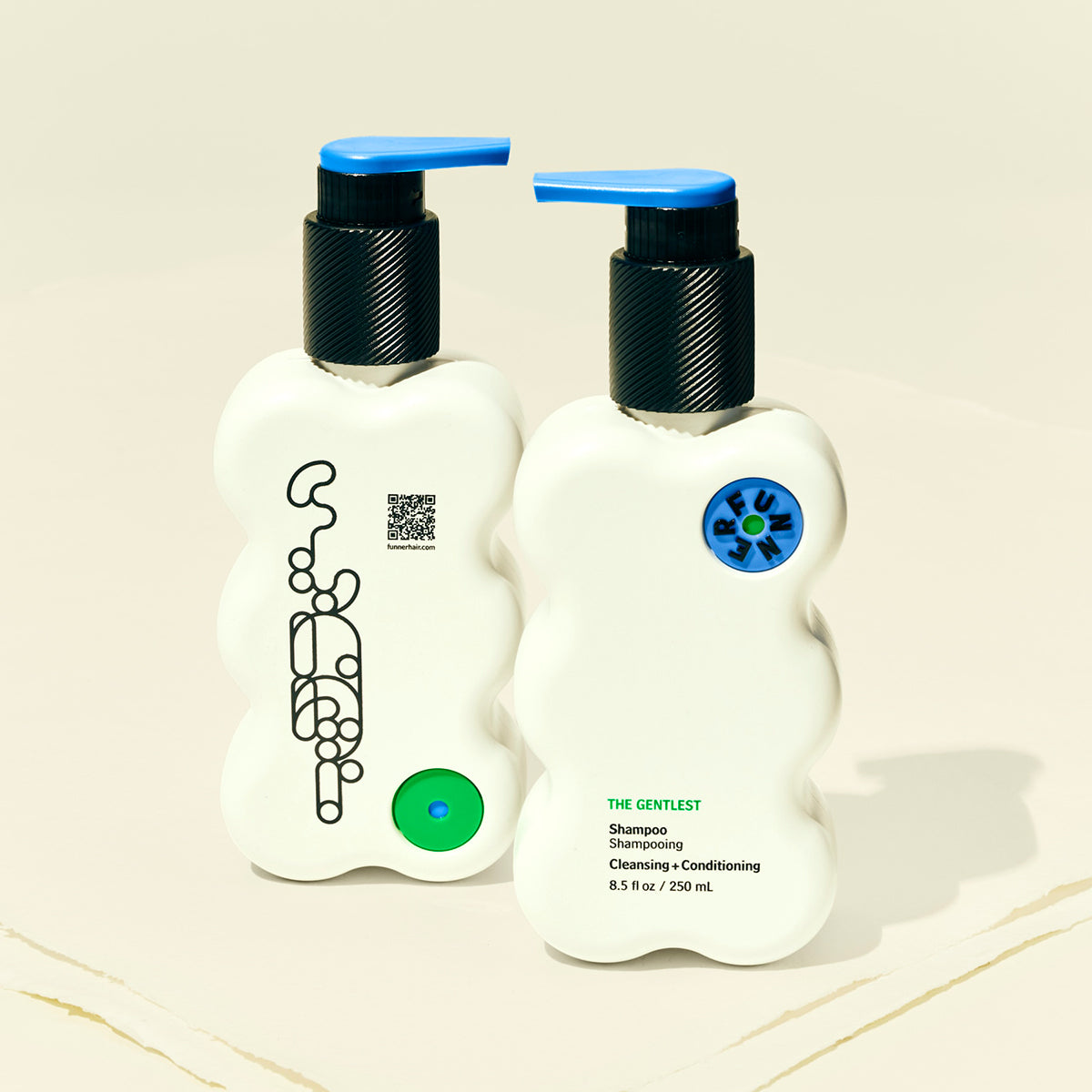 Two bottles of shampoo with pump dispensers on a beige background