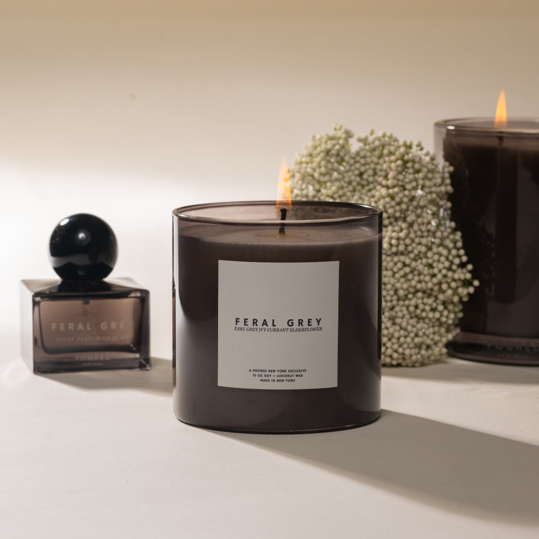 Feral Grey candle and perfume bottle on a light background