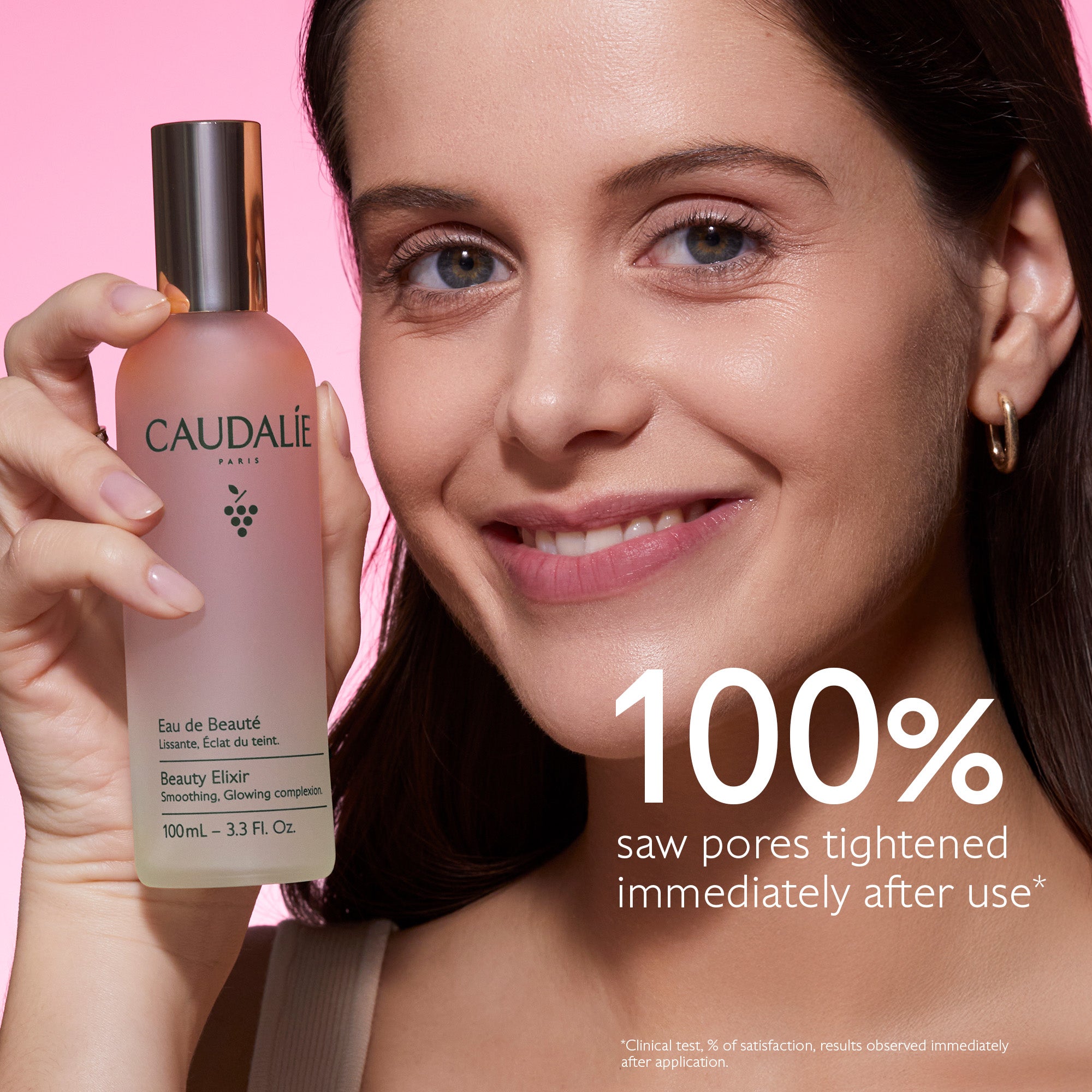 Woman holding a Caudalie skincare product with text on a pink background