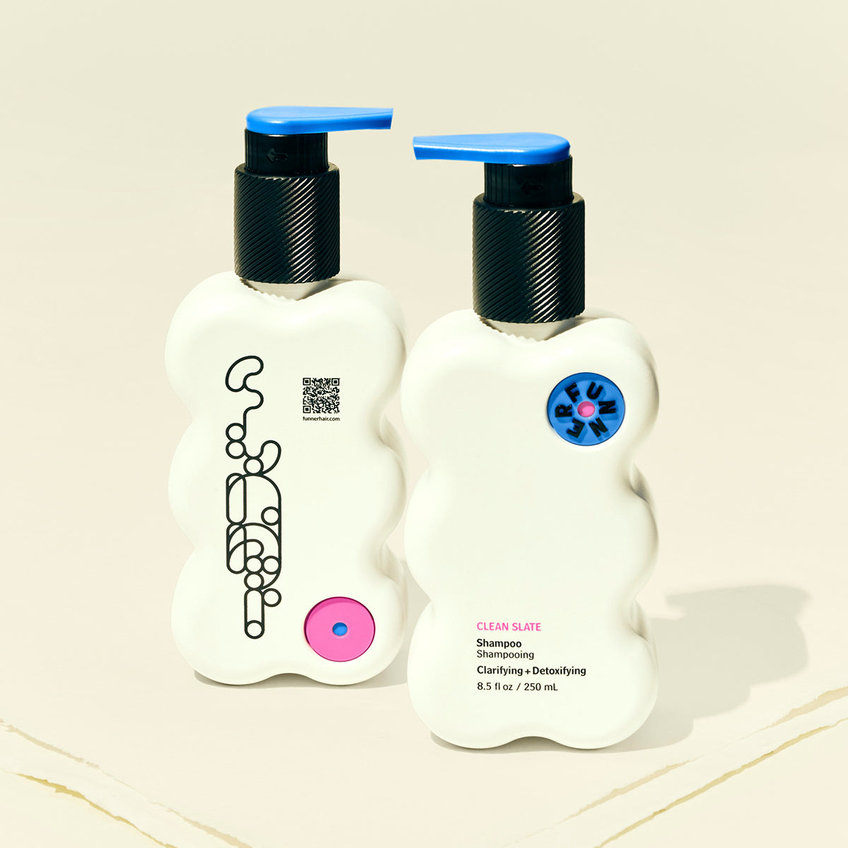 Two bottles of shampoo with pump dispensers on a beige background