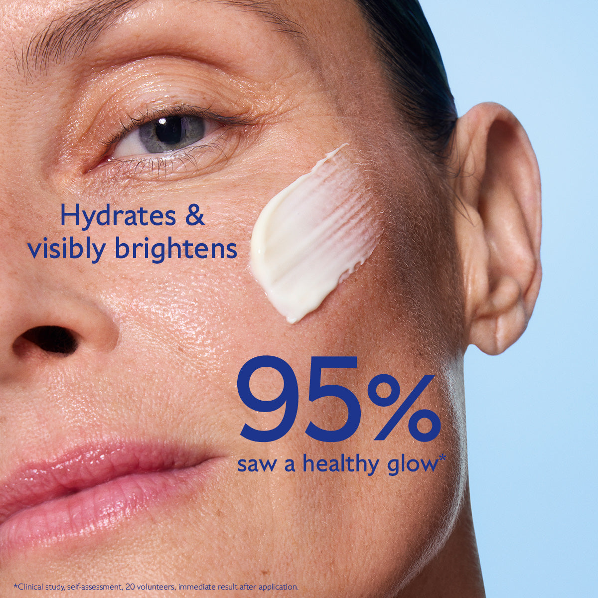 Close-up of a woman's face with cream applied, against a blue background.