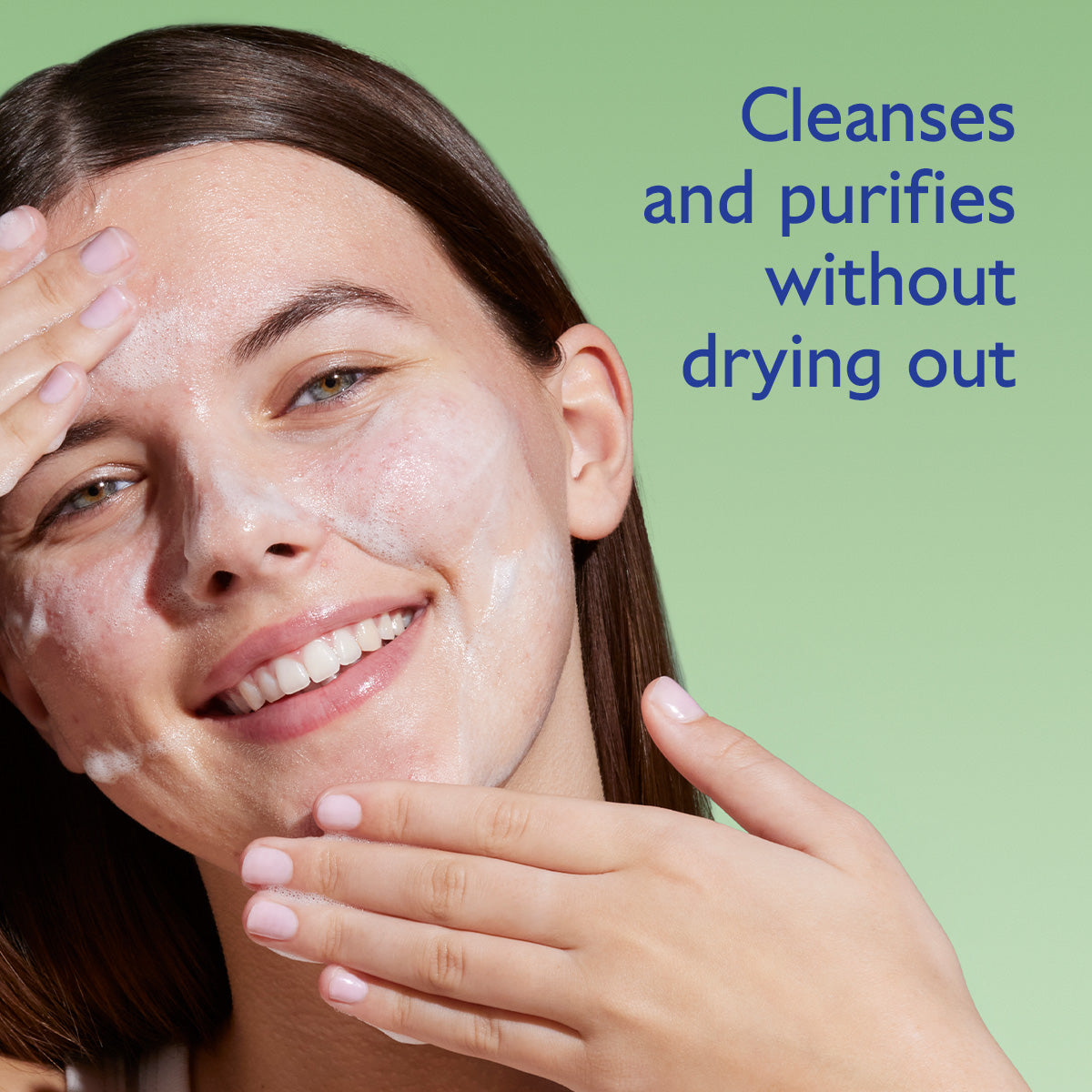 Woman applying facial cleanser with text 'Cleanses and purifies without drying out' on a green background