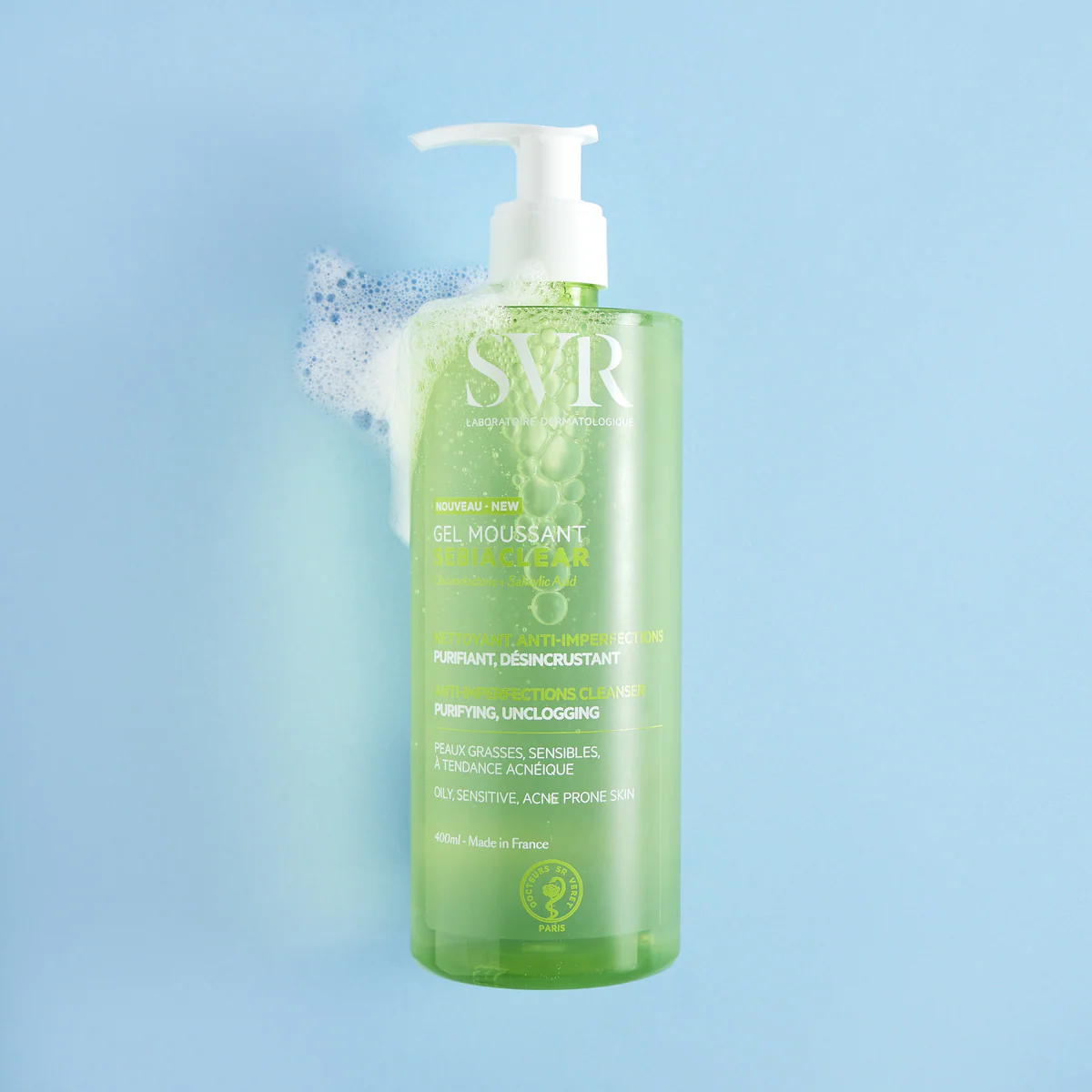 Green bottle with pump of SVR skincare product on a light blue background