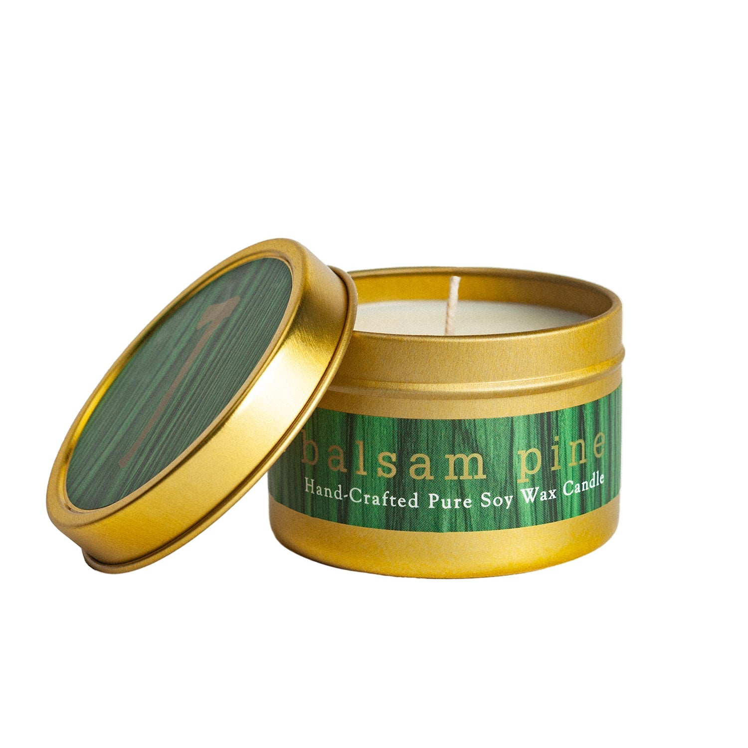 Candle in a gold tin with 'balsam pine' label on a white background