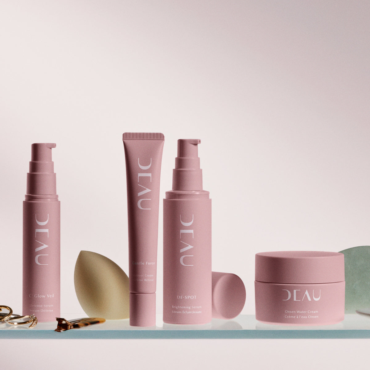 DEAU products on a clear surface with various other beauty objects
