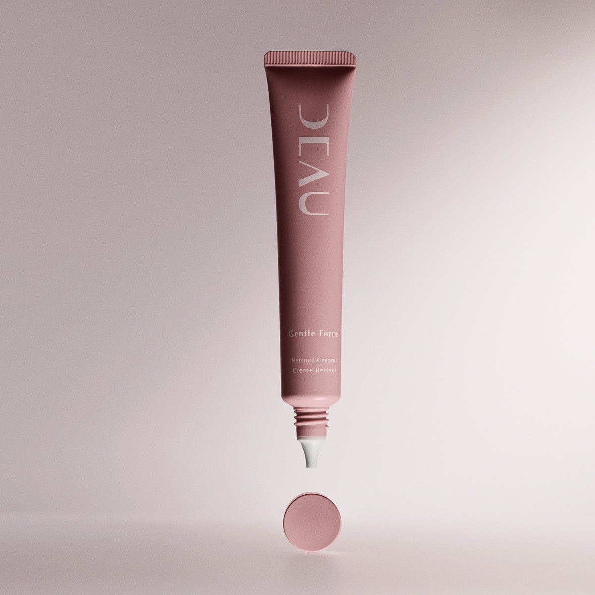 Pink skincare tube labeled 'DEAU' on a light pink background