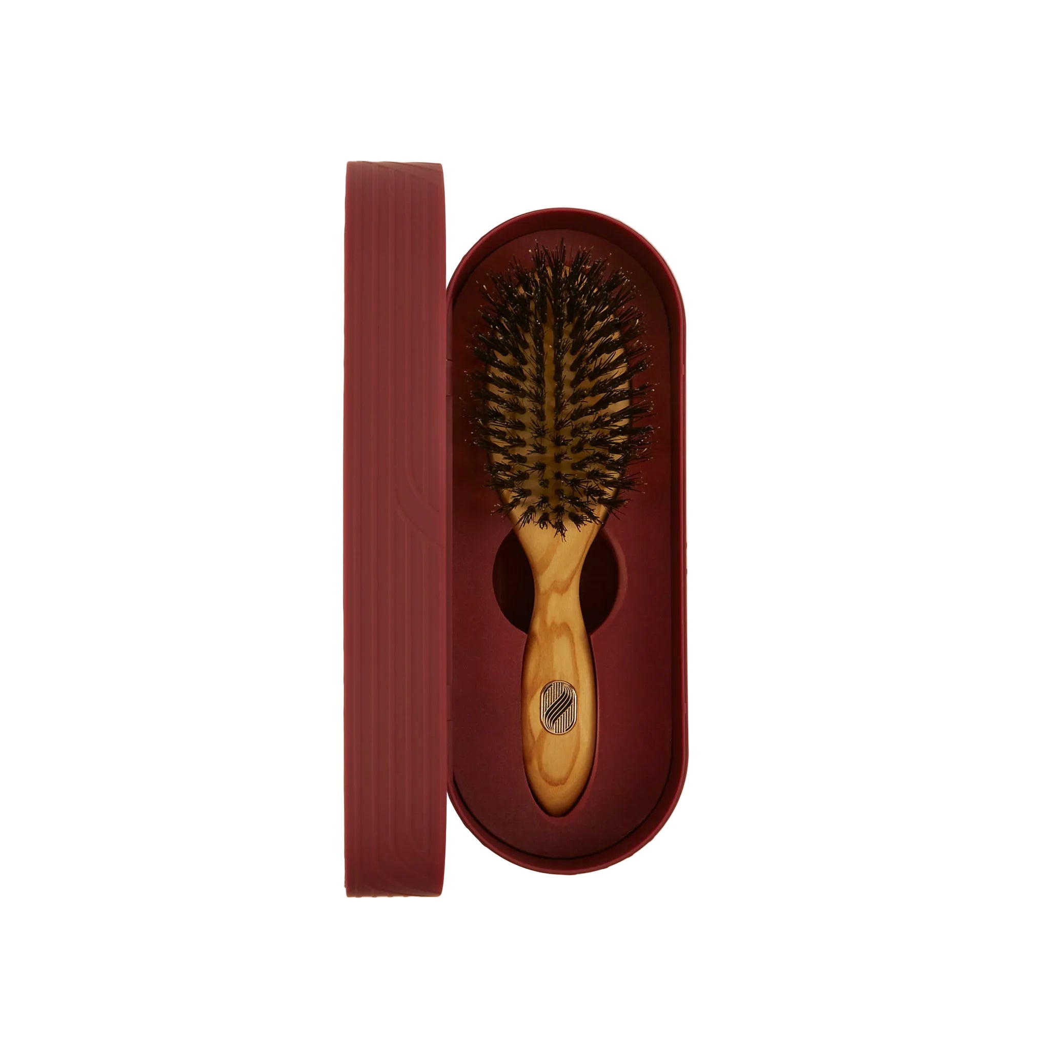 Wooden hairbrush with brown bristles in a matching brown case on a beige background