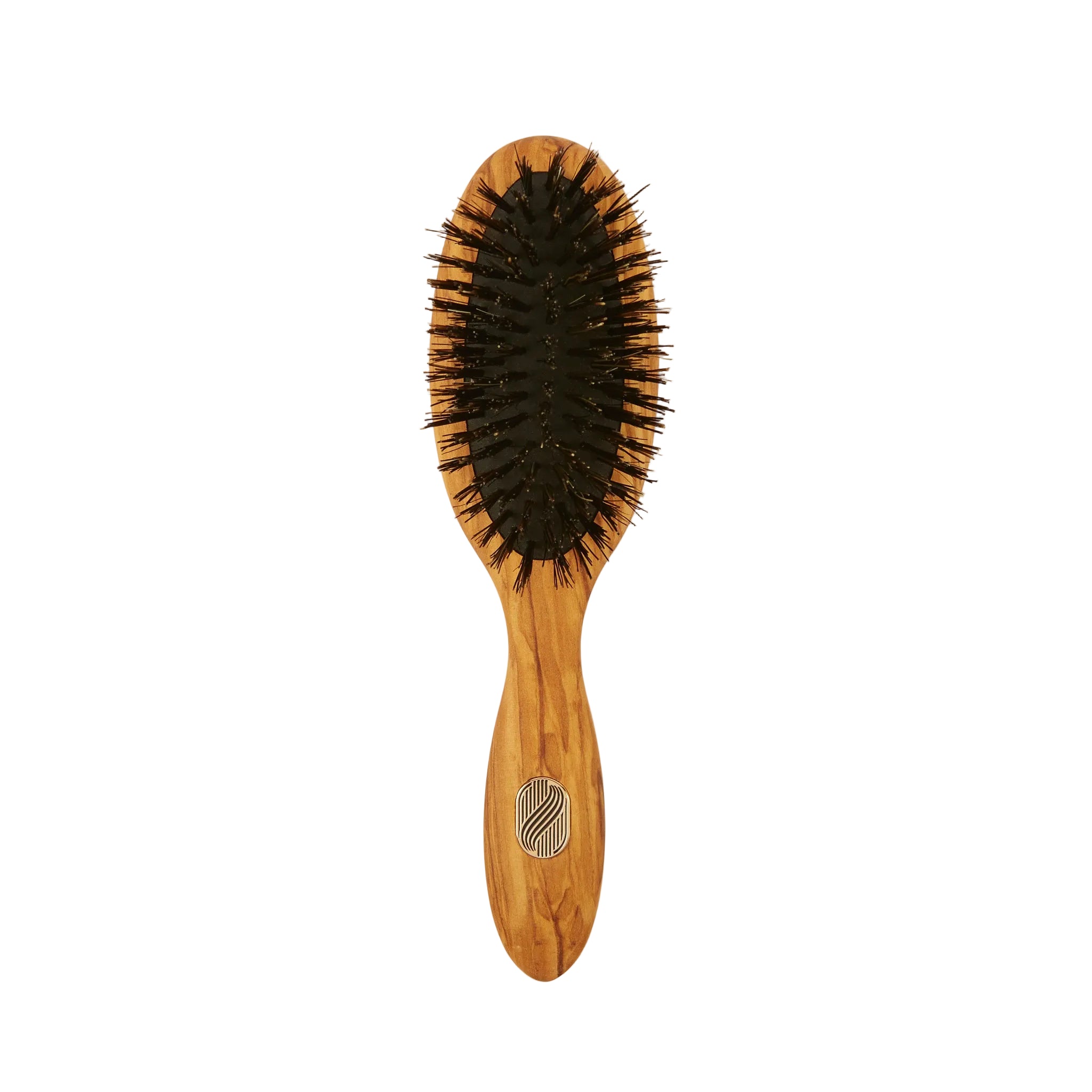 An oval-shaped wooden hairbrush with black bristles, featuring a light brown wood handle with a silver metal logo emblem, set against a plain off-white background.