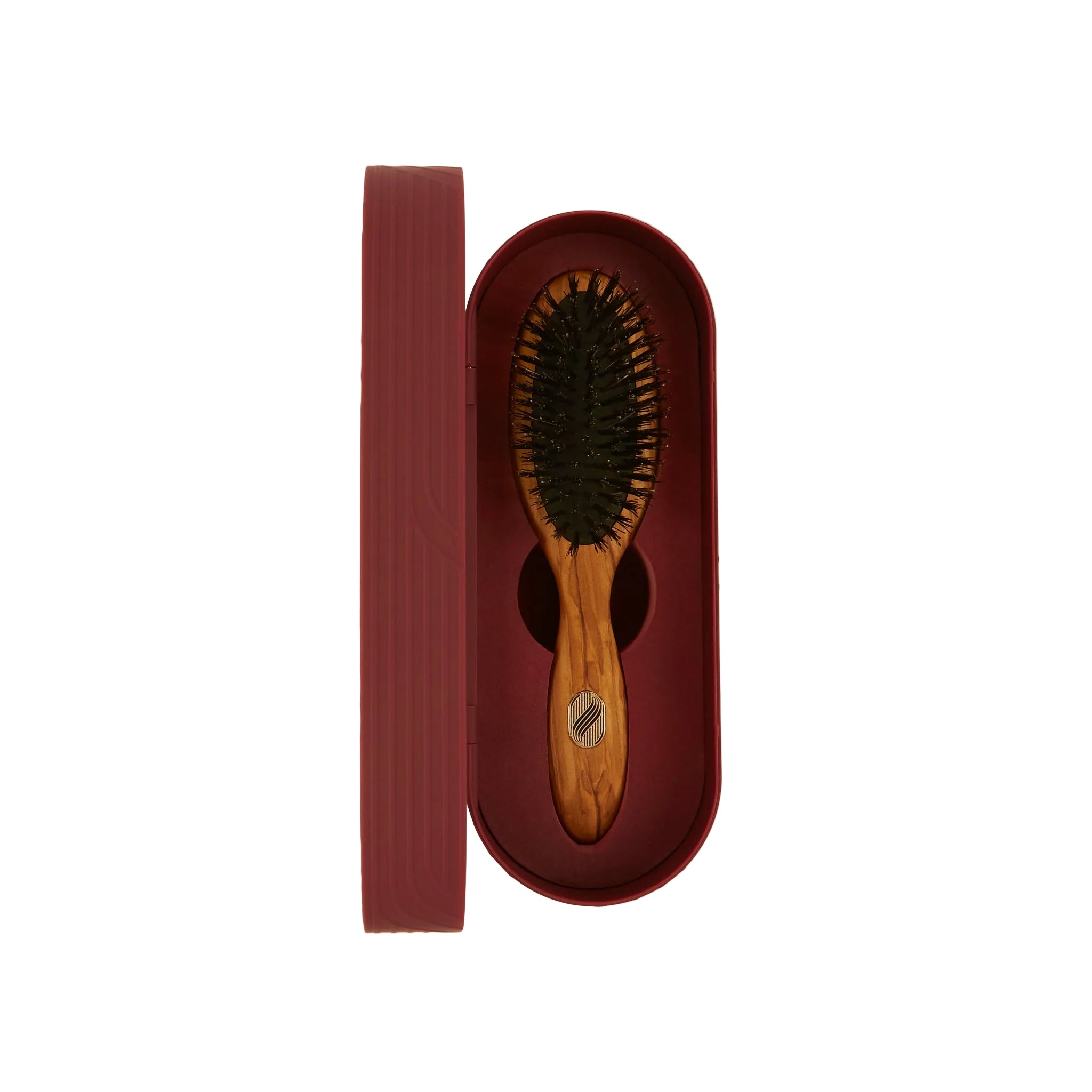 Wooden hairbrush in a red leather case on a beige background