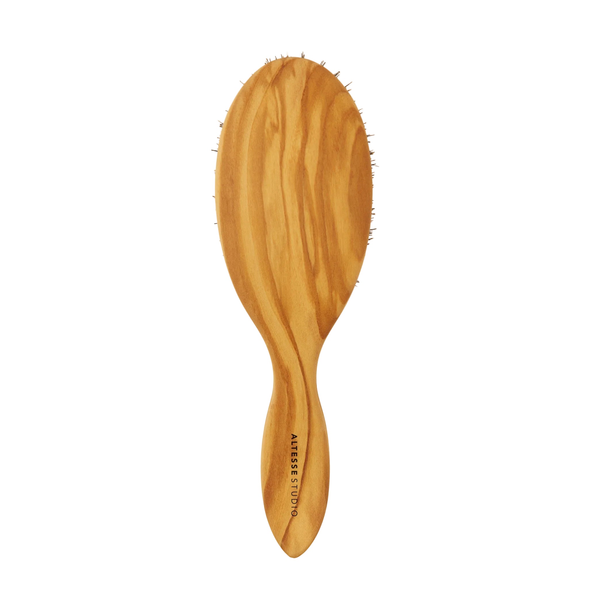 An oval wooden hairbrush with a natural olive wood grain finish and dark bristles, featuring the brand name  printed vertically on the handle, set against a plain off-white background.