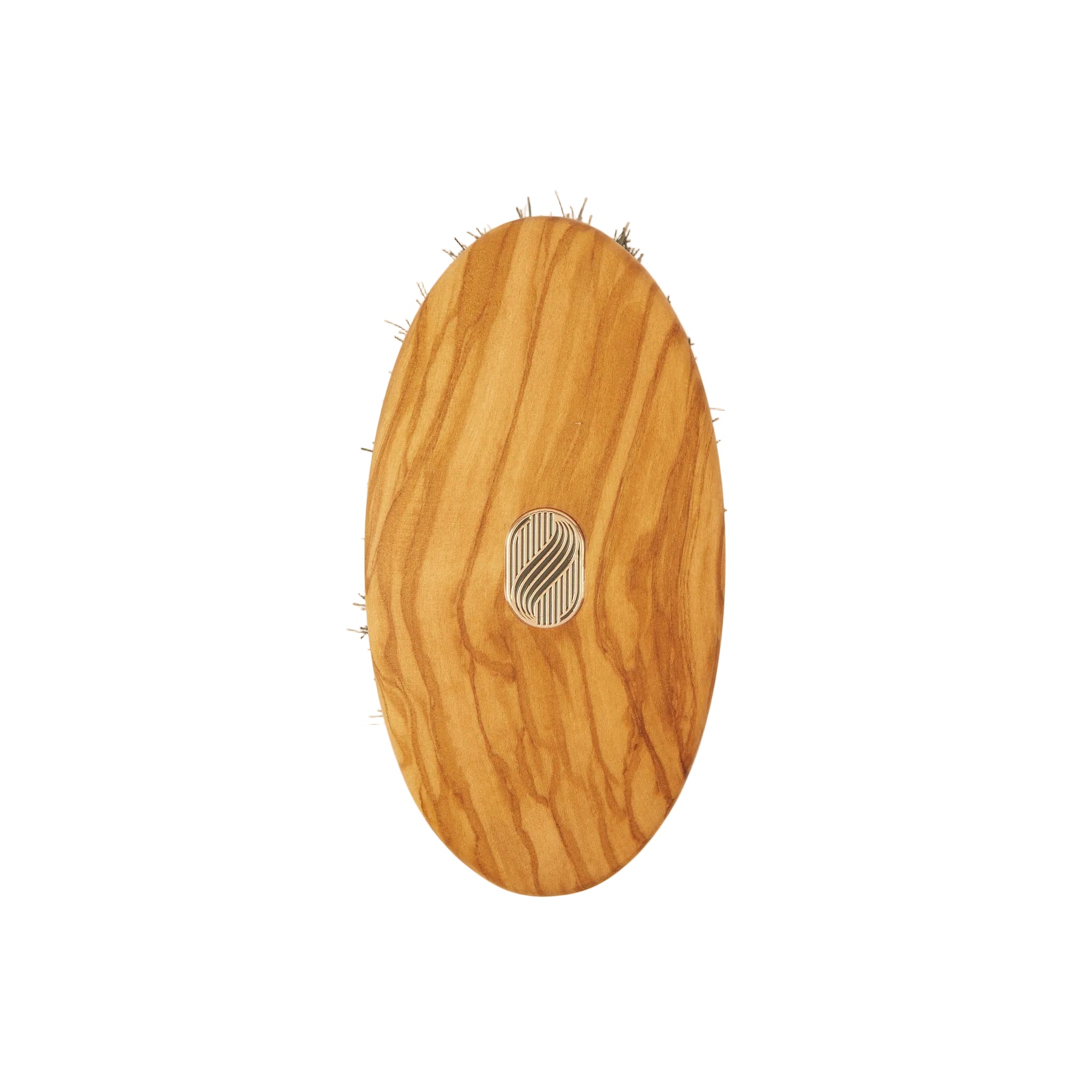 An oval wooden hairbrush with a natural olive wood grain finish and a small silver metal logo in the center, shown against a plain off-white background.