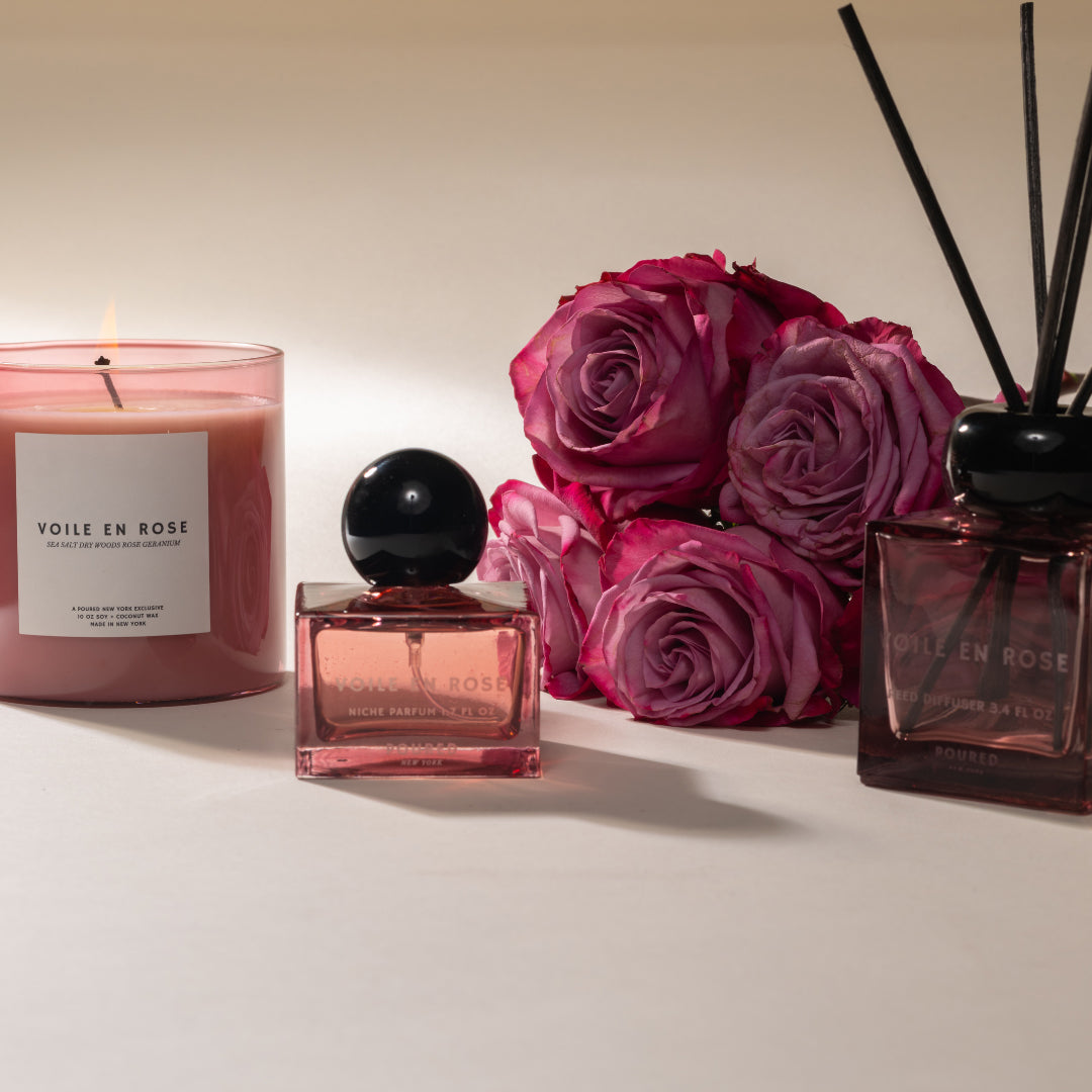 VOILE EN ROSE candle, perfume bottle, and diffuser with pink roses on a light background
