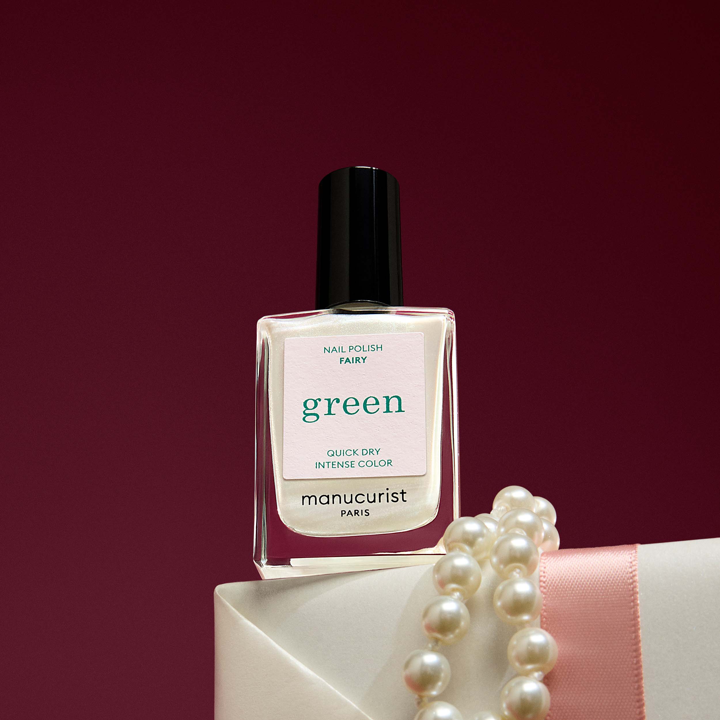 Manucurist Fairy nail polish bottle with pearls on a red background