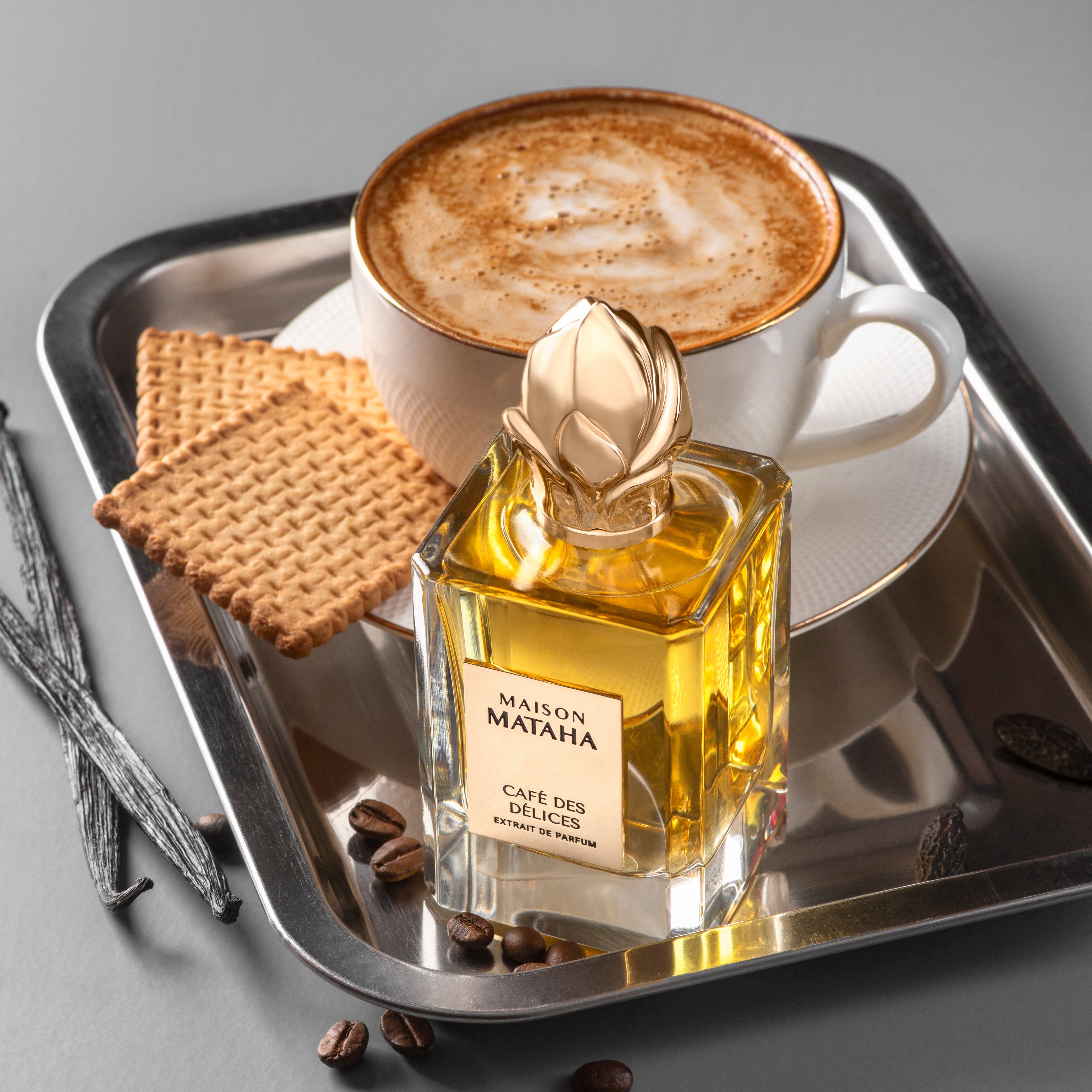 Perfume bottle on a tray with coffee and biscuits