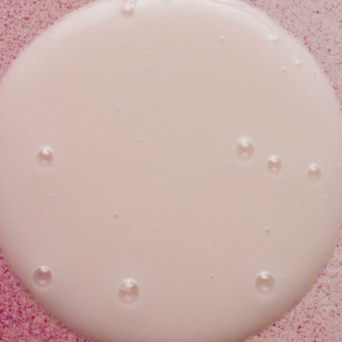 Close-up of a pink gelatin dessert with small white pearls on a pink textured background