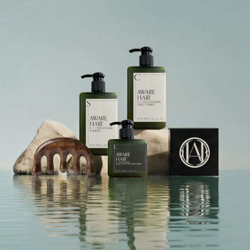 Aware Hair products including bottles, a comb, and a box on a reflective surface with a light blue background.