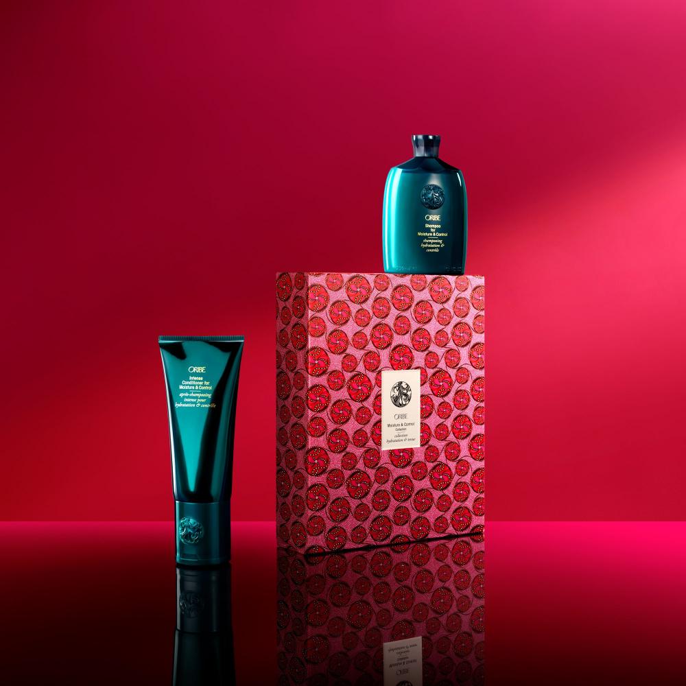 Moisture & Control Set alongside gift box packaging on a red backdrop 