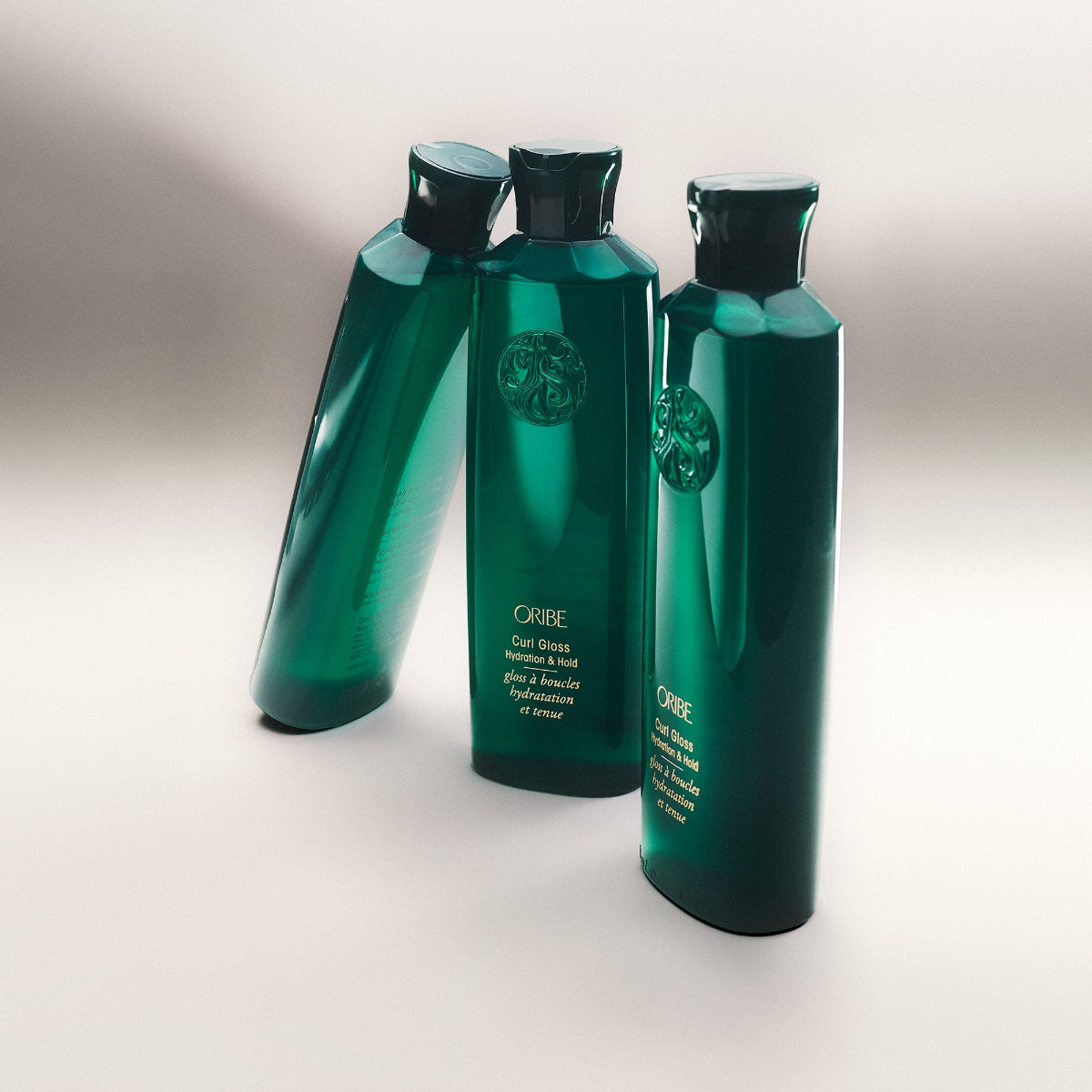 Three green bottles with Oribe logo on a light gray background