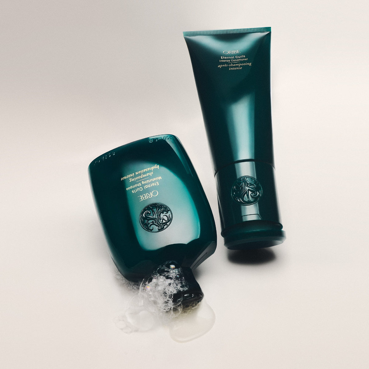 Two green haircare products on a light gray background