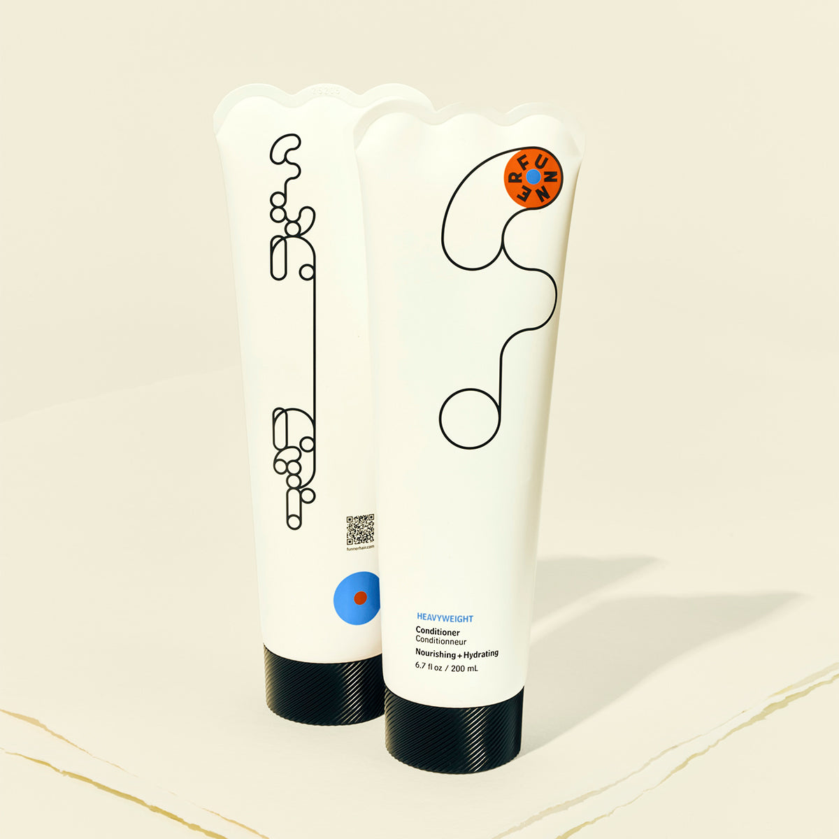 Two tubes of hair care product with abstract designs on a beige background