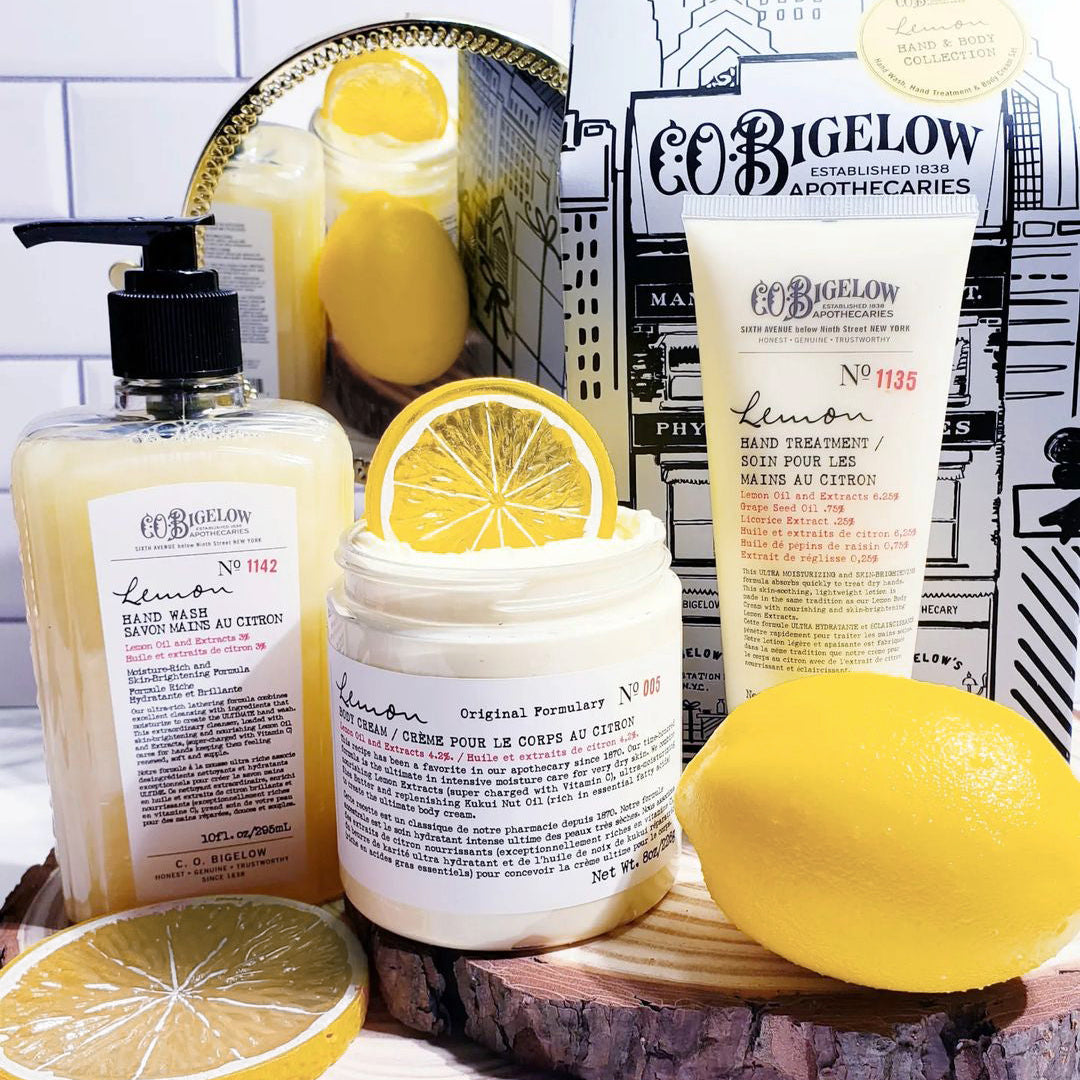 C.O. Bigelow lemon body products including a bottle, jar, and tube on a wooden surface with lemons.
