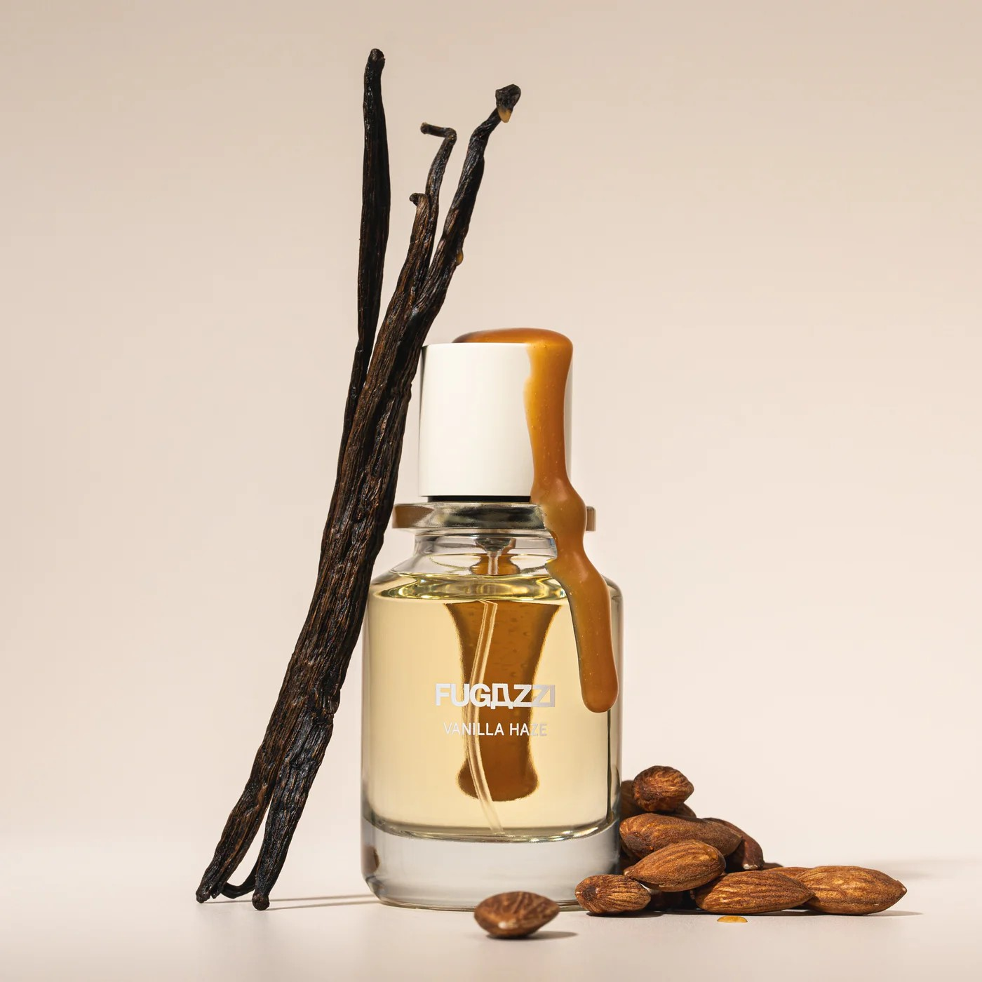 fugazzi vanilla haze perfume bottle with vanilla beans and almonds around it.