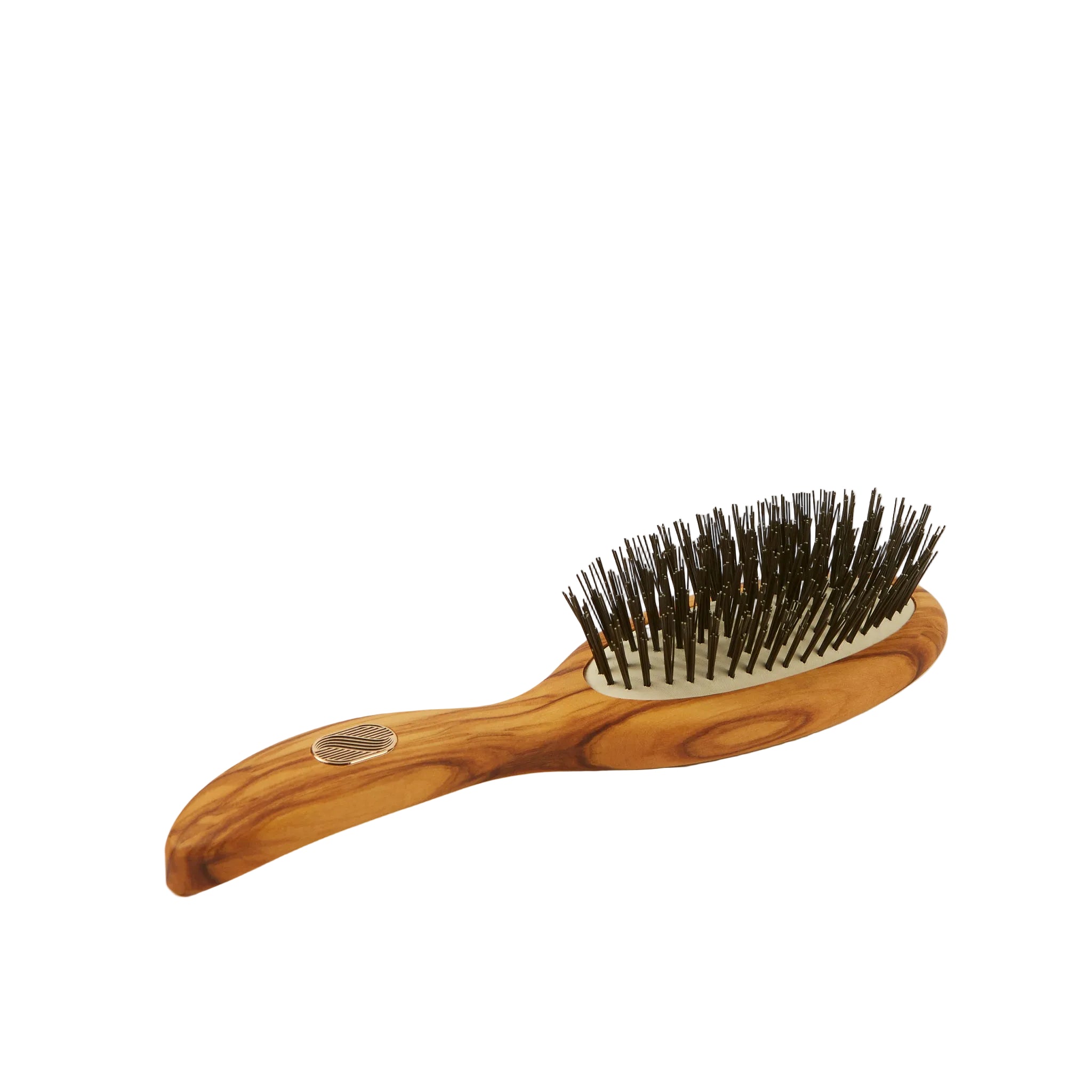 An olive wood hairbrush with dark brown bristles and a small round metal emblem on the handle, set against a plain light beige background.