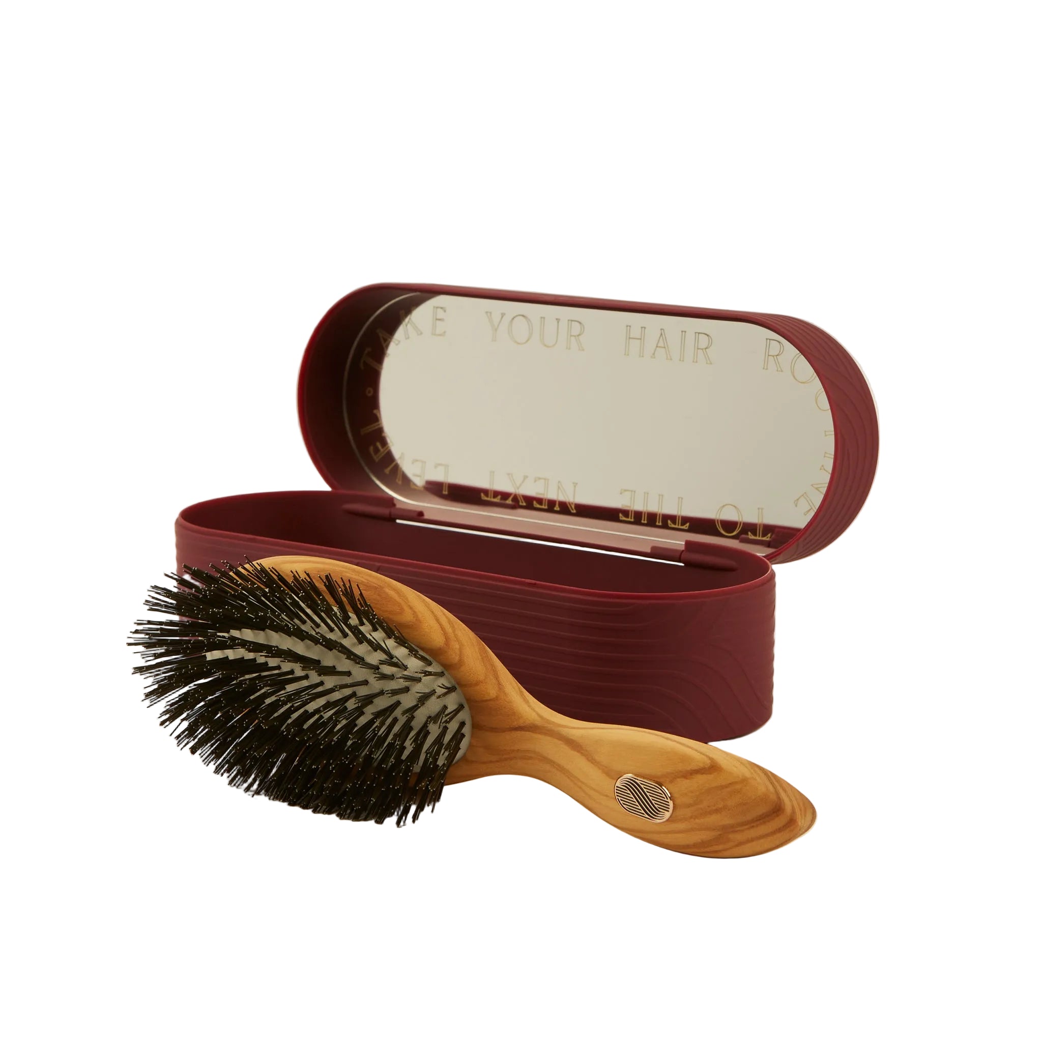 Wooden hairbrush with black bristles and a red case on a beige background