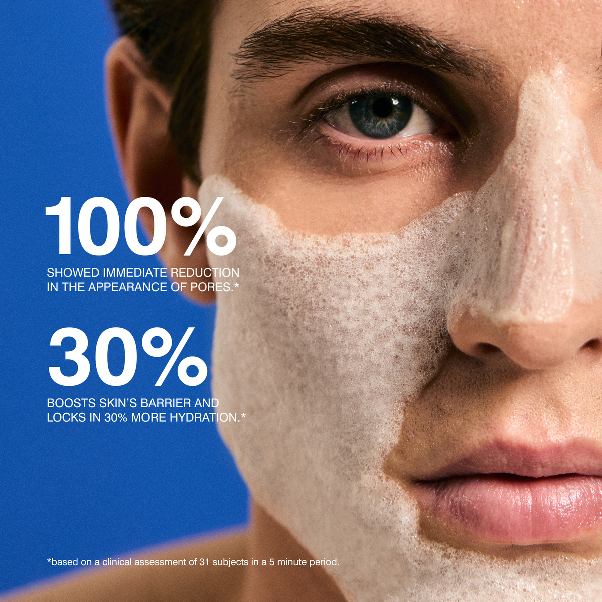 Close-up of a man's face with a white foaming skincare product applied across his cheek and nose, set against a bright blue background with large white text claiming 100% immediate pore reduction and 30% increased hydration.