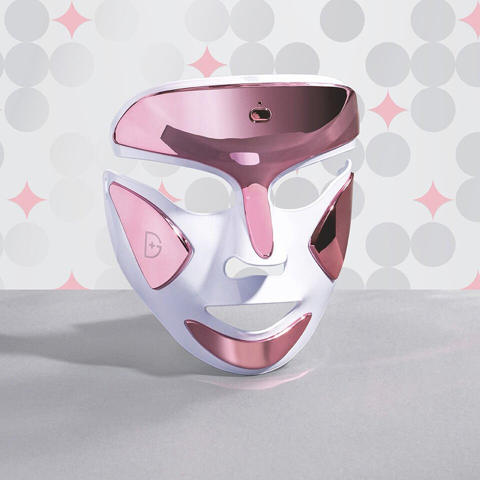 Pink and white facial mask on a gray surface with a patterned background