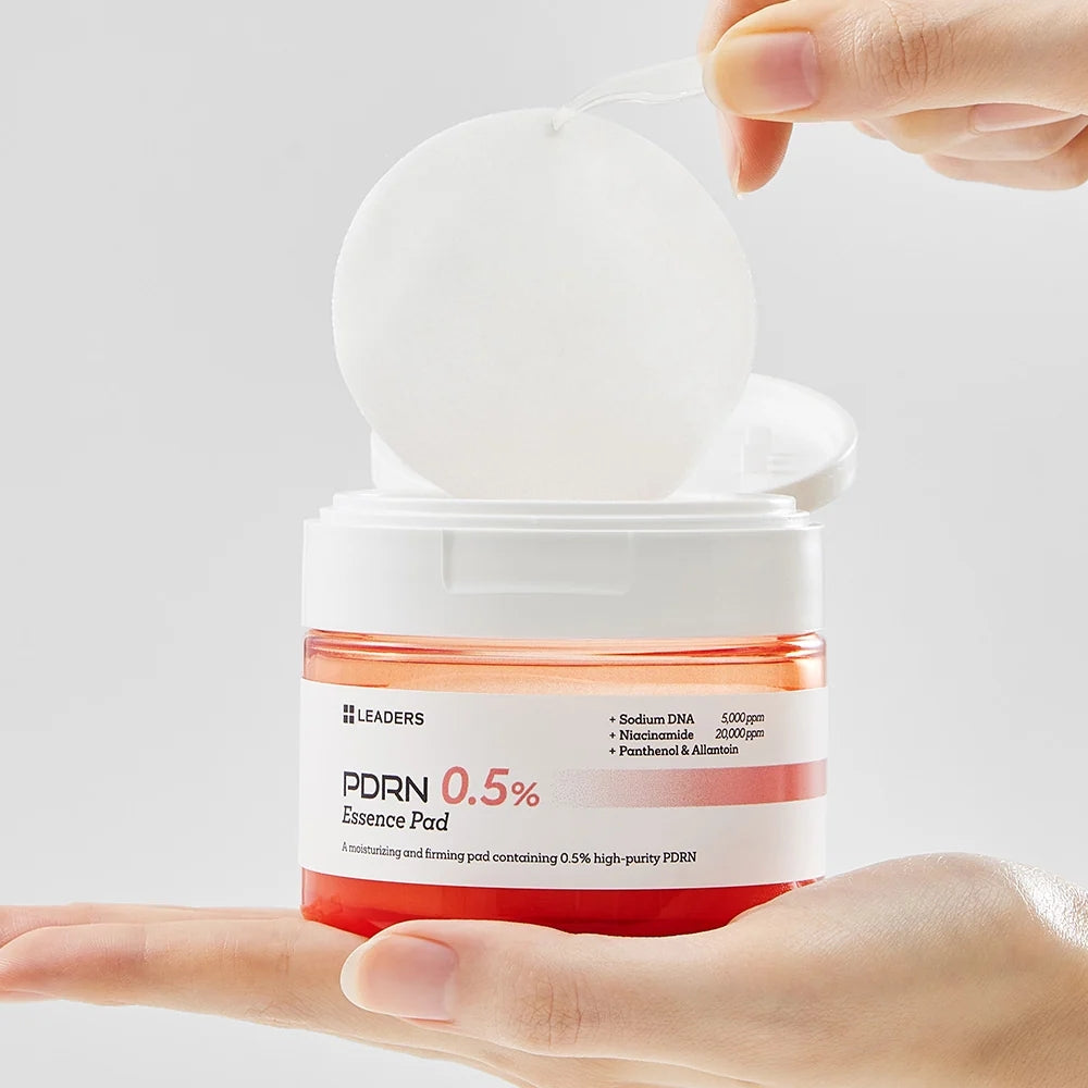Jar of Leaders PDRN Essence Pad with a hand holding it against a light gray background
