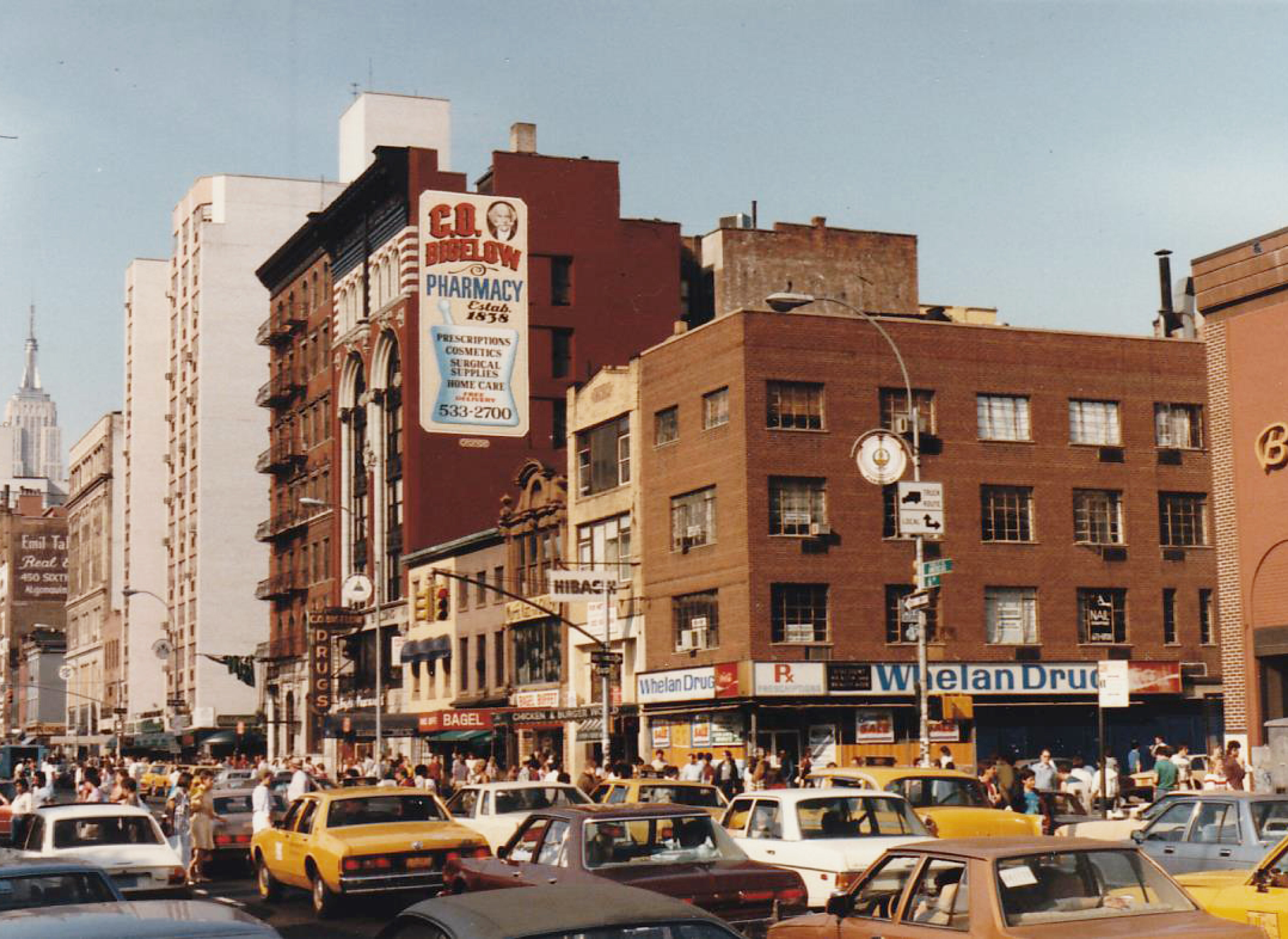 6th Ave view of CO Bigelow, teeming with cars and people, illustrating the dynamic nature of urban environments.